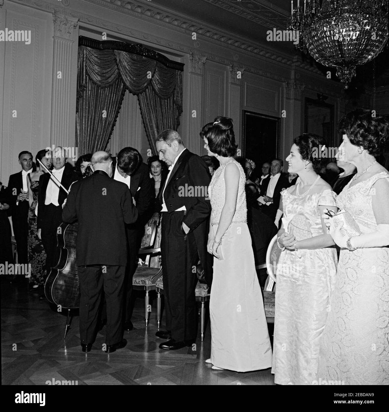 Abendessen zu Ehren des Gouverneurs Luis Muu00f1oz Maru00edn von Puerto Rico, 8:00pm Uhr. Der Cellist Pablo Casals spricht mit Präsident John F. Kennedy, nachdem er bei einem Abendessen zu Ehren des Gouverneurs von Puerto Rico auftrat. (L-R) Abraham Ribicoff, Secretary of Health, Education, and Welfare; Mary Louise Day; Postmaster General J. Edward Day; Inu00e9s Mendoza de Muu00f1oz (teilweise versteckt); Mr. Casals; President Kennedy; Governor of Puerto Rico Luis Muu00f1oz Maru00edn; First Lady Jacqueline Kennedy; Marta Casals; Rose Kennedy. East Room, White House, Washington, D.C. Stockfoto