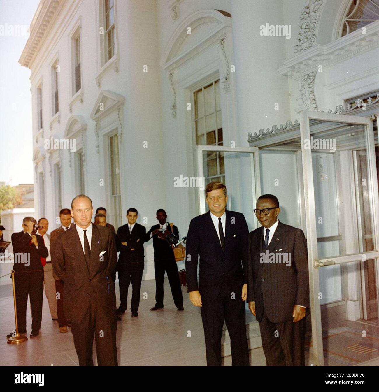 Mittagessen zu Ehren von William Vacanarat Shadrach Tubman, Präsident von Liberia, 1:00 Uhr. Mittagessen zu Ehren von William V.S. Tubman, Präsident von Liberia. (L u2013 R): Protokollchef Angier Biddle Duke; Präsident John F. Kennedy; Präsident Tubman. Verschiedene nicht identifizierte Reporter und Fotografen im Hintergrund. North Portico, White House, Washington, D.C. Stockfoto