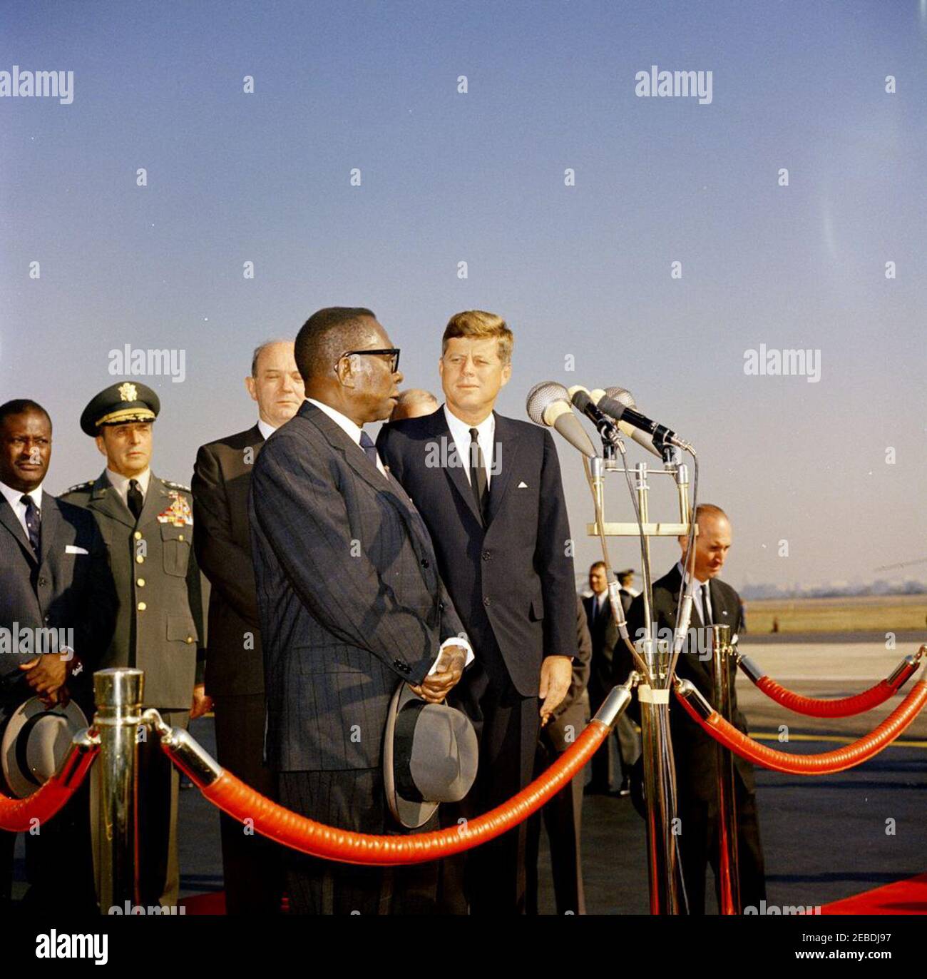 Ankunftszeremonie für William Vacanarat Shadrach Tubman, Präsident von Liberia, 10:00 UHR. Ankunftszeremonien für William V.S. Tubman, Präsident von Liberia. Auf Plattform, erste Reihe (L u2013 R): Präsident Tubman (an Mikrofonen); Präsident John F. Kennedy. Zweite Reihe: Vorsitzender der Generalstabschefs Lyman Lemnitzer; Staatssekretär Dean Rusk. Chef des Protokolls Angier Biddle Duke (rechts von der Plattform). Andrews Air Force Base, Maryland. Stockfoto