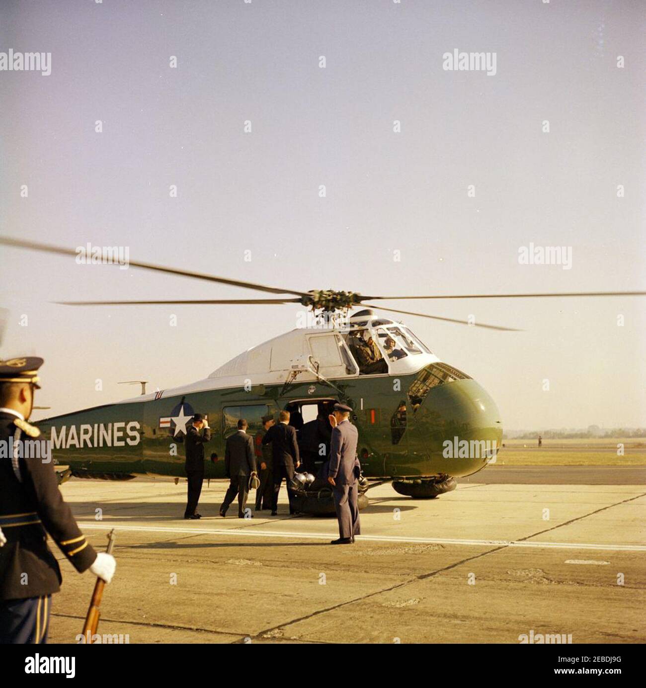 Ankunftszeremonie für William Vacanarat Shadrach Tubman, Präsident von Liberia, 10:00 UHR. Ankunftszeremonien für William V.S. Tubman, Präsident von Liberia. Protokollchef Angier Biddle Duke (ganz links, mit Hut), Präsident John F. Kennedy (Mitte, zurück zur Kamera) und andere nähern sich dem Hubschrauber des US-Marine Corps. Andrews Air Force Base, Maryland. Stockfoto