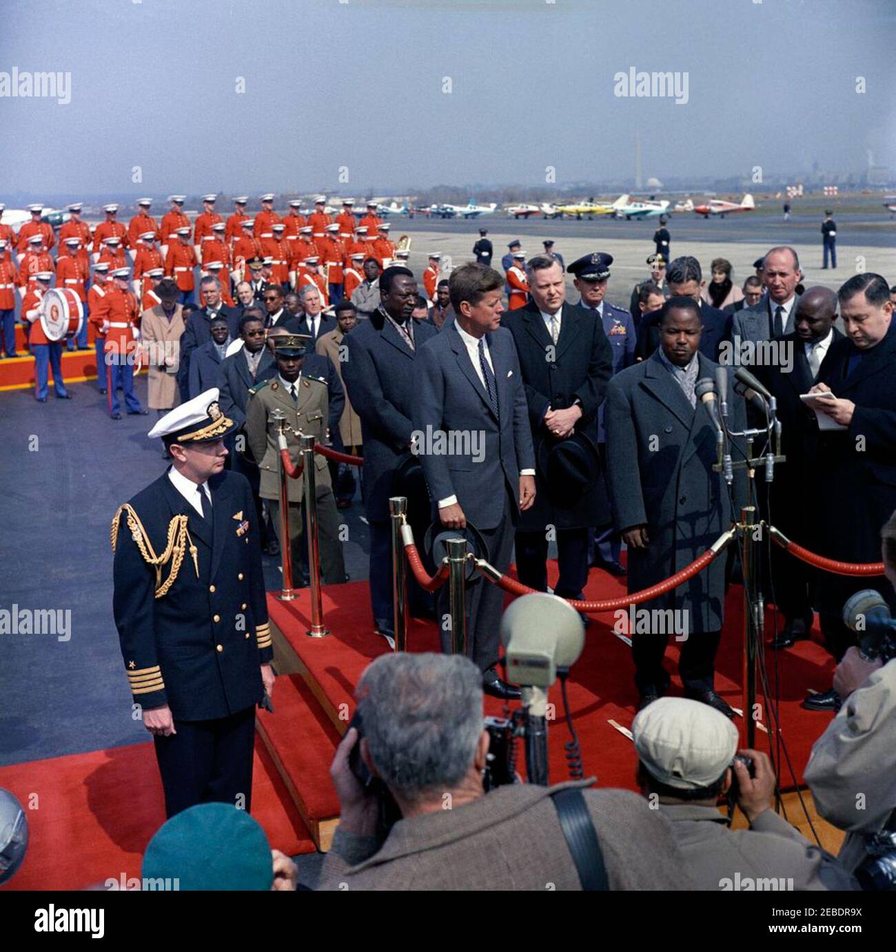 Ankunftszeremonie für Ahmadou Ahidjo, Präsident von Kamerun, 11:00am Uhr. Präsident John F. Kennedy nimmt an den Ankunftszeremonien für den Präsidenten von Kamerun, Ahmadou Ahidjo, Teil. Auf der Überprüfungsplattform (L-R): Bundesaußenminister von Kamerun, Jean Faustin Betayene; Präsident Kennedy; zwei unbekannte Männer; Präsident Ahidjo (AT-Mikrofone); US-Protokollchef Angier Biddle Duke (hinten); kamerunischer Botschafter in den Vereinigten Staaten, Jacques Kuoh Moukouri; US-Außenministerium-Dolmetscher Edmund S. Glenn. Naval Aide to President Kennedy, Captain Tazewell Shepard, steht ganz links Stockfoto