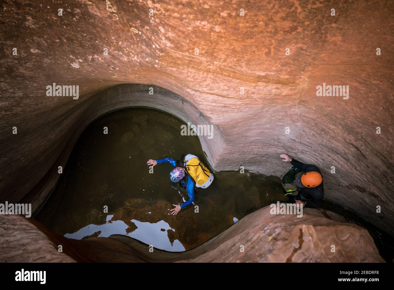 Zwei Männer waten durch Brust tiefes Wasser zu navigieren ein Slot Canyon Stockfoto