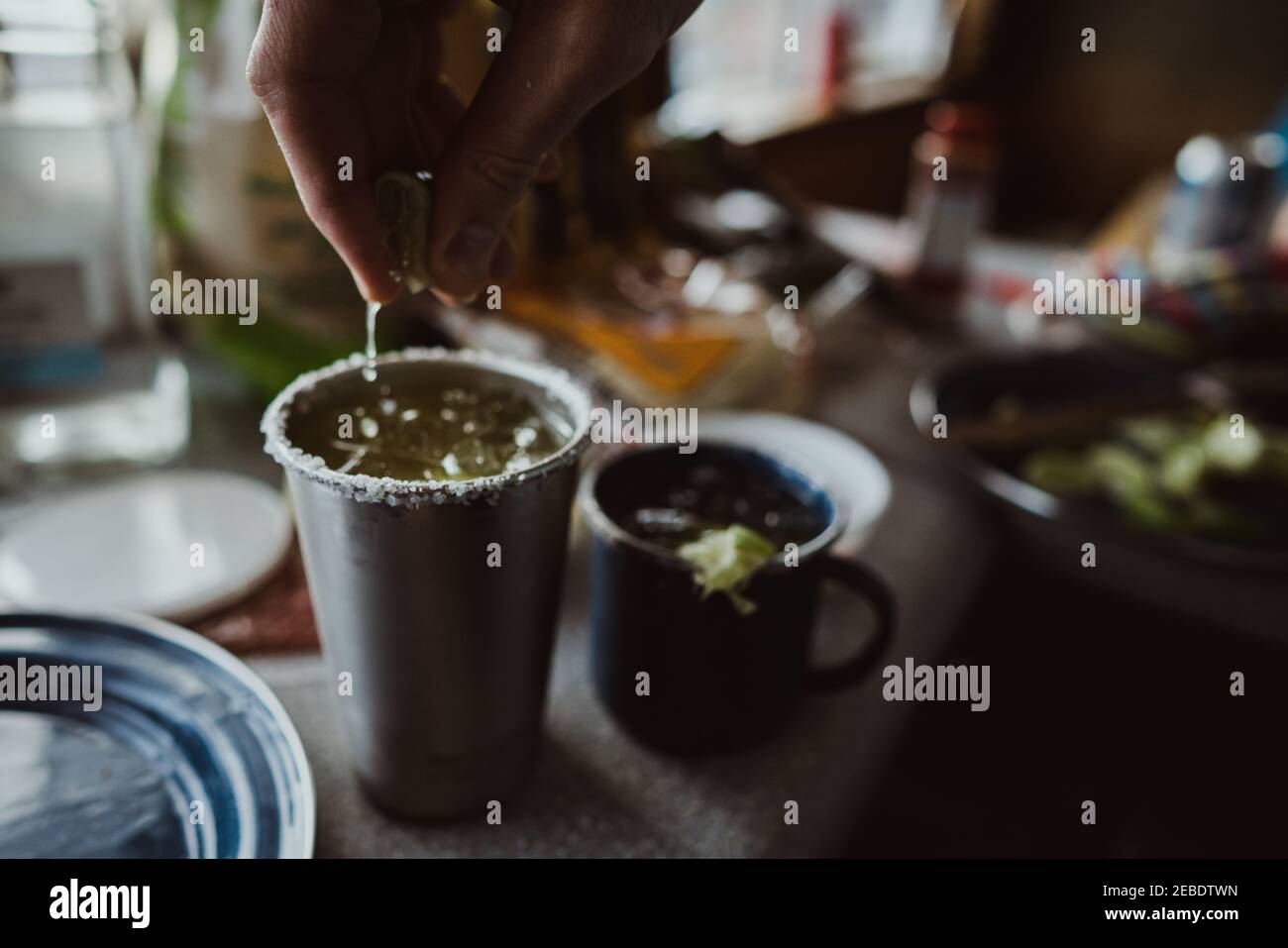 Nahaufnahme der Hand, die eine Limette in eine zusammendrückt Rustikale margarita Stockfoto