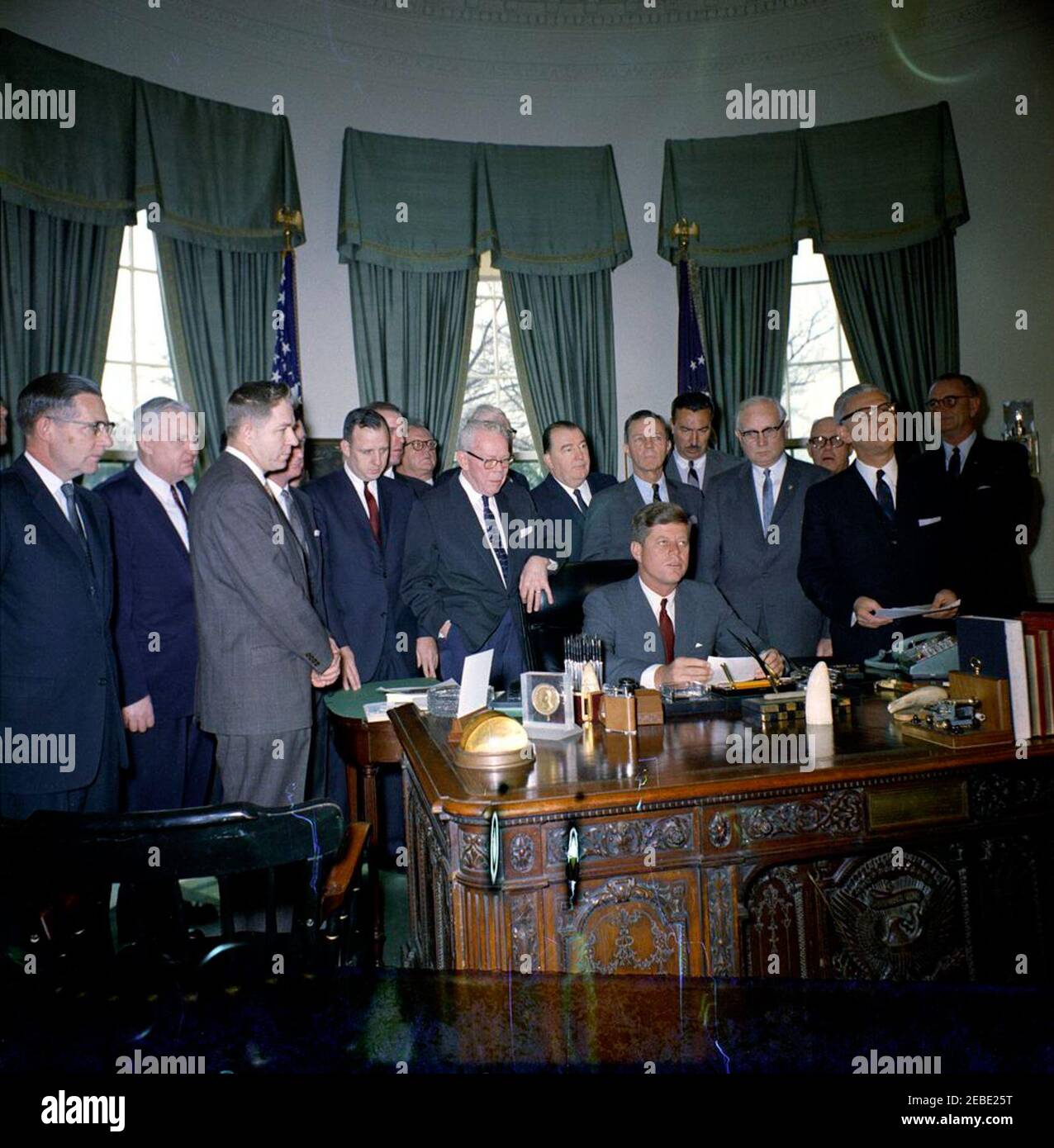 Bill Signing - S. 1991 Öffentliches Recht 415, Manpower Development u0026 Training Act, 10:31am. Präsident John F. Kennedy (sitzt am Schreibtisch) hält Bemerkungen bei der Bill-Signing für die Manpower Development and Training Act (Public Law 415). Blick auf (L-R): Senator Winston L. Prouty (Vermont); Kongressabgeordneter Carl D. Perkins (Kentucky); Kongressabgeordneter Neal Smith (Iowa); Kongressabgeordneter Charles E. Goodell (New York); Kongressabgeordneter Peter A. Garland von Maine (hinter Goodell); Direktor des Department of Legislation for the American Federation of Labor and Congress of Industrial Organizations (AFL-CIO), Andrew J. Stockfoto