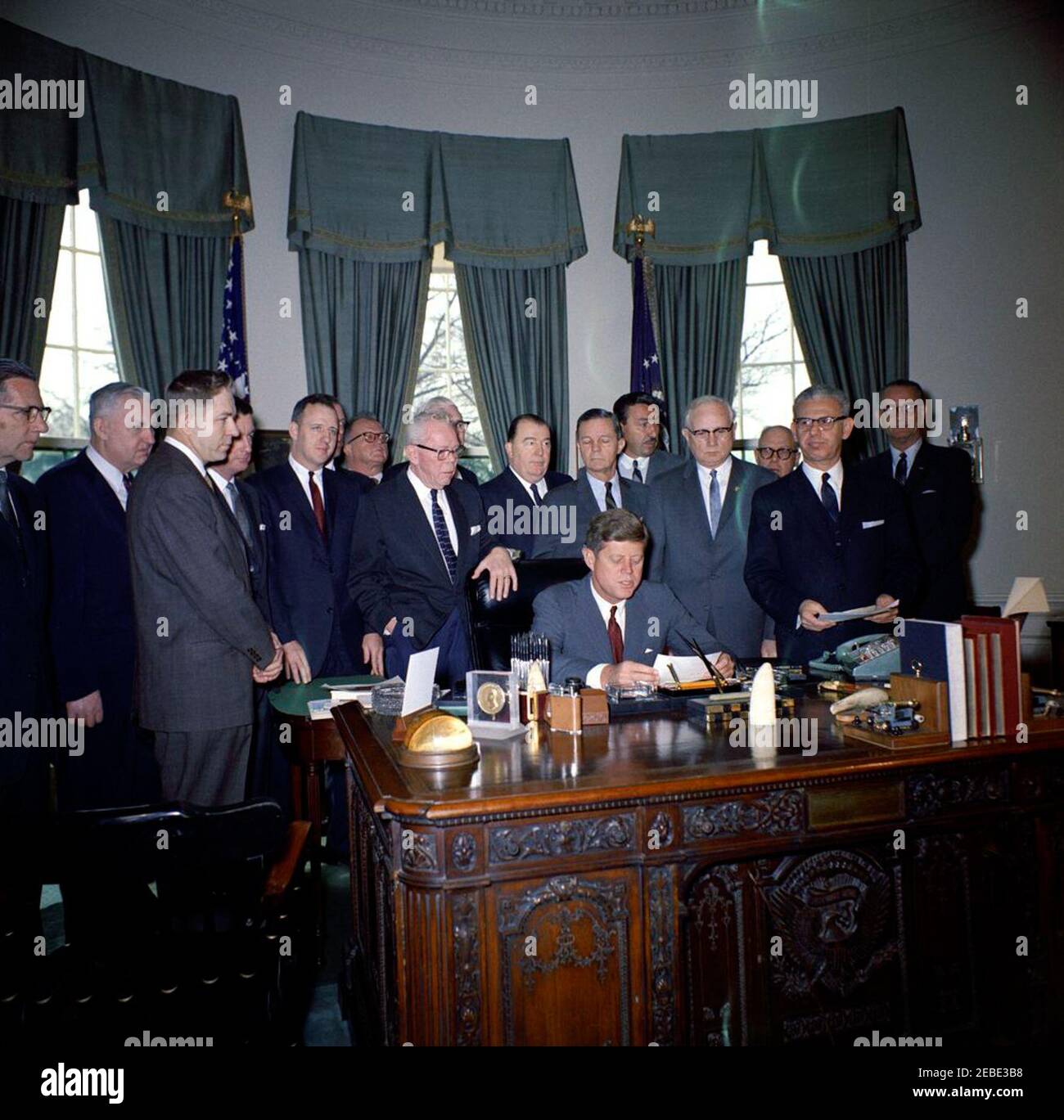 Bill Signing - S. 1991 Öffentliches Recht 415, Manpower Development u0026 Training Act, 10:31am. Präsident John F. Kennedy (sitzt am Schreibtisch) hält Bemerkungen bei der Bill-Signing für die Manpower Development and Training Act (Public Law 415). Blick auf (L-R): Senator Winston L. Prouty (Vermont); Kongressabgeordneter Carl D. Perkins (Kentucky); Kongressabgeordneter Neal Smith (Iowa); Senator Maurice J. Murphy, Jr. (New Hampshire); Kongressabgeordneter Charles E. Goodell (New York); Direktor des Department of Legislation für die American Federation of Labor and Congress of Industrial Organizations (AFL-CIO), Andrew J. Biemille Stockfoto