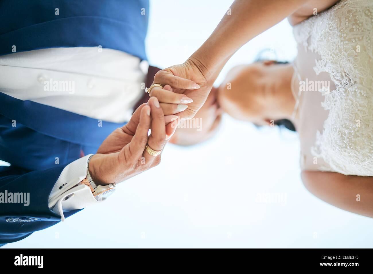 Hochzeitspaar hält oben die Hände POV Stockfoto