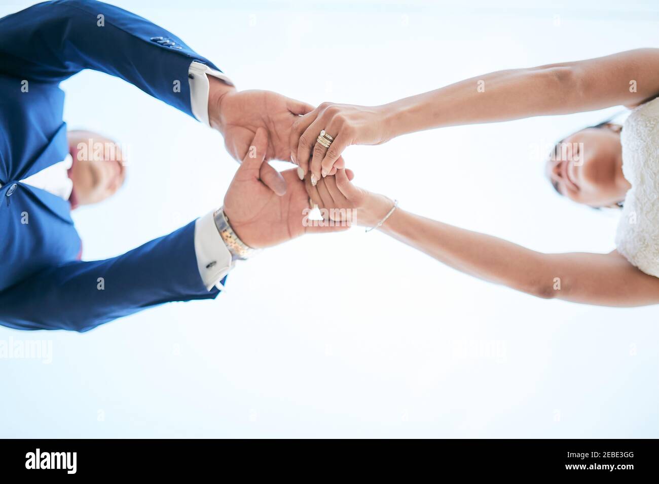 Frisch verheiratetes Paar, das die Hände in einer Bottom-up-Position hält Stockfoto
