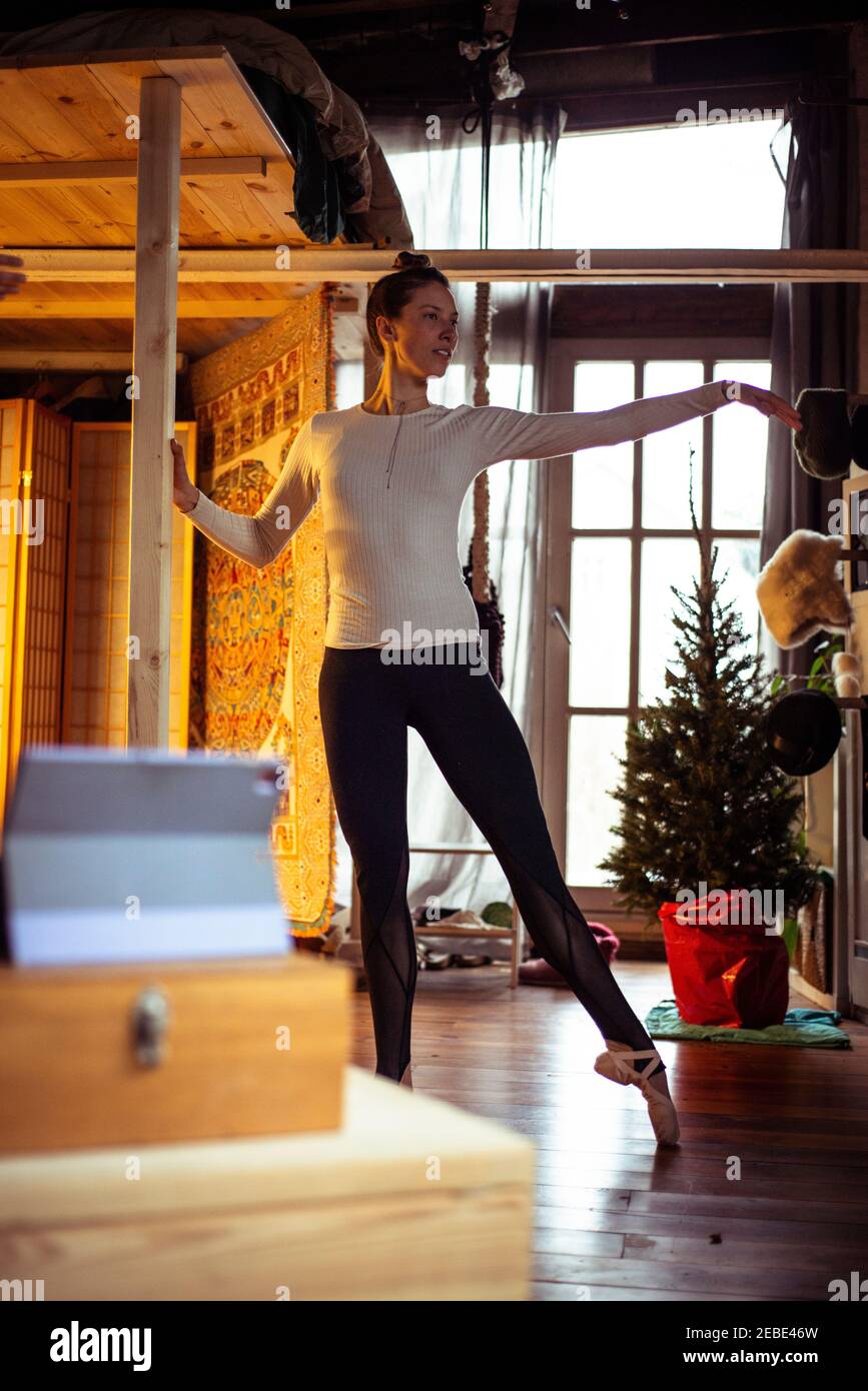 Ballerina übt Bar Ballett auf Zoom Video-Klasse zu Hause Im Winter Stockfoto