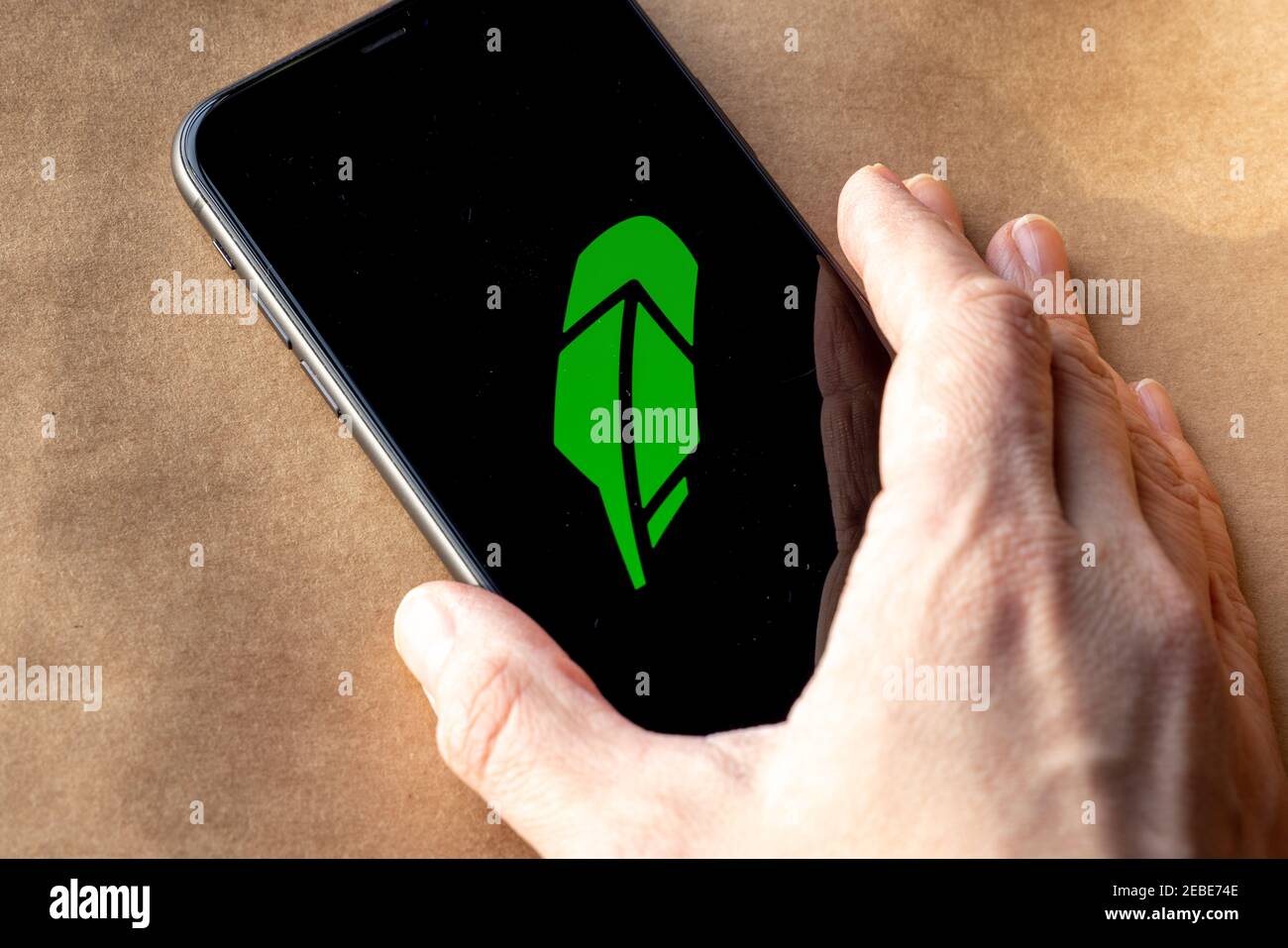 Robinhood auf iPhone Display auf braunem Öko Papier. Robinhood ist eine Free-Trading-App ohne Gebühren zu bezahlen. Robinhood Stockfoto