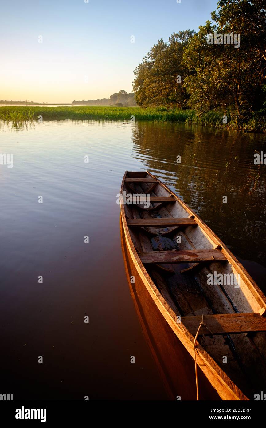 Ein Boot schwimmt auf dem Amazonas bei Sonnenuntergang in Mocagua, Amazonas, Kolumbien. Stockfoto