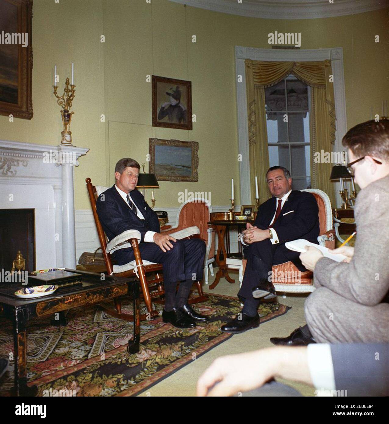 Treffen mit Dr. Erich Mende, Vorsitzender der Freien Demokratischen Partei, Westdeutschland, 4:00pm Uhr. Präsident John F. Kennedy (im Schaukelstuhl) trifft sich mit dem Vorsitzenden der Freien Demokratischen Partei Westdeutschlands, Dr. Erich Mende (rechts sitzend). Der Mensch ganz rechts ist nicht identifiziert. Yellow Oval Room, White House, Washington, D.C. Stockfoto