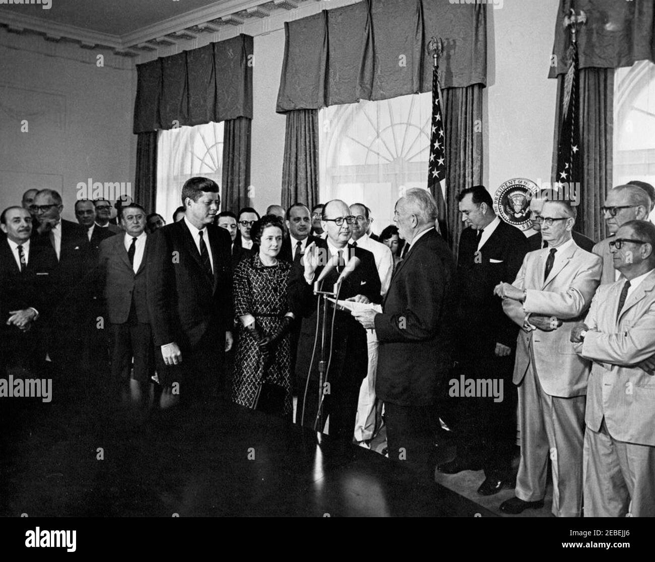 Vereidigung, deLesseps S. Morrison, Sr., US-Repräsentant bei der Organisation amerikanischer Staaten (OAS), und Robert Woodward, stellvertretender Staatssekretär für interamerikanische Angelegenheiten, 11:05am Uhr. Vereidigung von DeLesseps Morrison als Botschafter der Vereinigten Staaten bei der Organisation amerikanischer Staaten (OAS) und Robert F. Woodward als stellvertretender Staatssekretär für interamerikanische Angelegenheiten. (L u2013 R): Präsident John F. Kennedy; Virginia Woodward; Robert Woodward (Eid abnehmend); deLesseps Morrison (hinter Woodward, trägt weißen Anzug); Frank K. Sanderson, White House Administrative Stockfoto