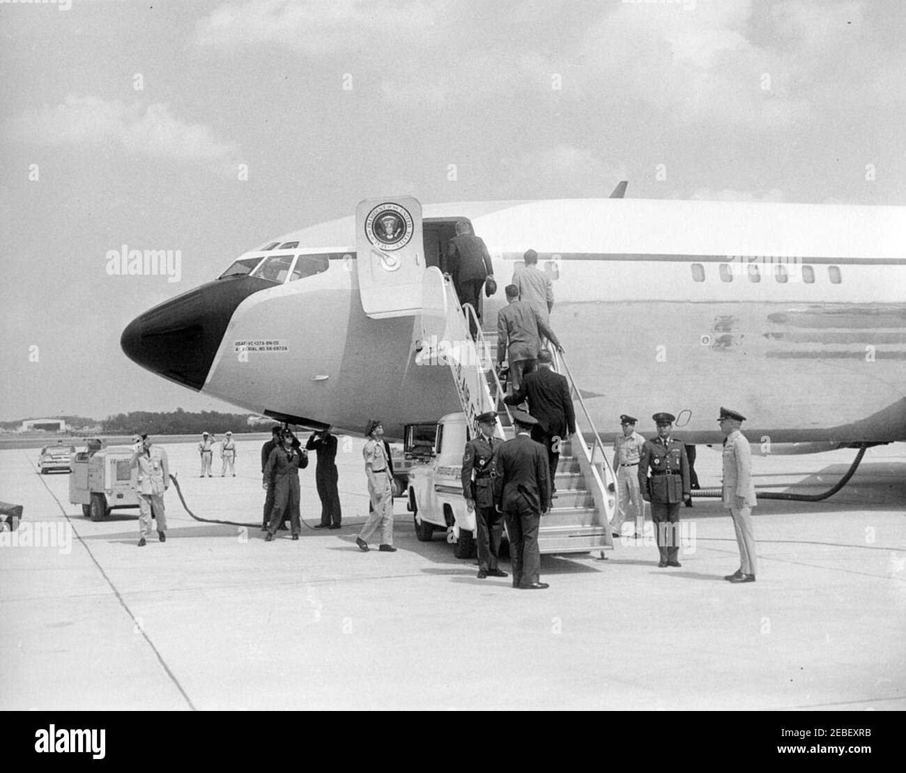 Präsident Kennedy verlässt den Luftwaffenstützpunkt Andrews nach Palm Beach, Florida, um 3:33pm Uhr. Präsident John F. Kennedy (mit einem Hut) und Helfer besteigen ein Flugzeug und verlassen den Luftwaffenstützpunkt Andrews in Maryland nach Palm Beach, Florida. Stockfoto