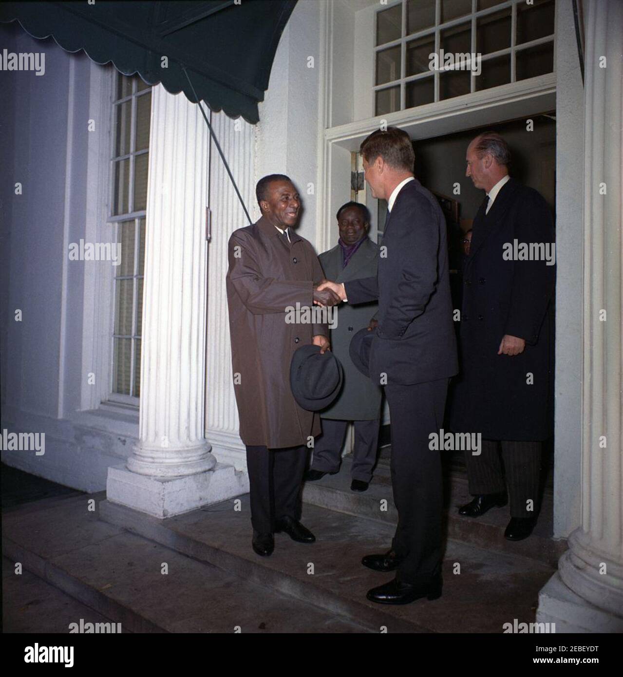 Treffen mit Sylvanus Olympio, Präsident von Togo, 2:53pm Uhr. Präsident John F. Kennedy schüttelt die Hände mit Präsident von Togo, Sylvanus Olympio (links), nach Präsident Olympiou2019s Abreise aus dem Weißen Haus nach einem Treffen und Mittagessen. Der Außenminister von Togo, Paulin Freitas, steht zwischen Präsident Kennedy und Präsident Olympio, der Chef des US-Protokolls, Angier Biddle Duke, steht ganz rechts. Eingang im Westflügel, weißes Haus, Washington, D.C. Stockfoto