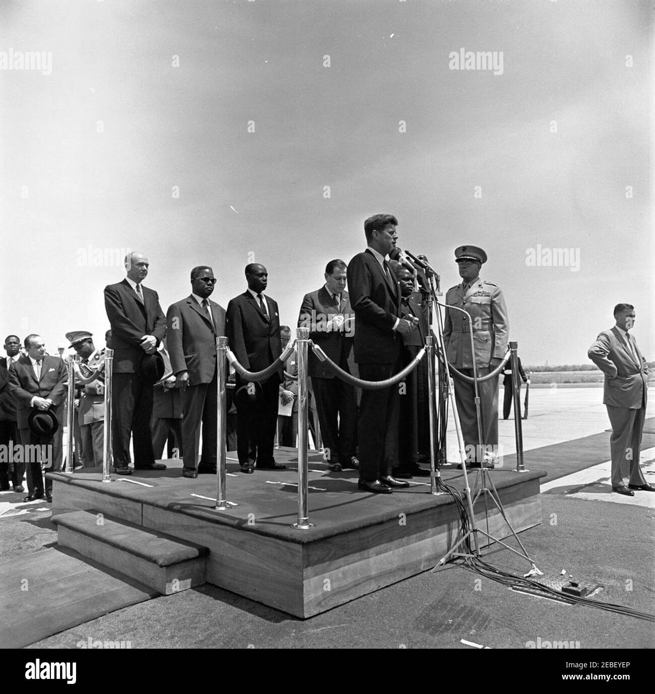 Ankunftszeremonie für Fulbert Youlou, Präsident der Republik Kongo (Brazzaville), 12:00pm Uhr. Präsident John F. Kennedy gibt Grußworte an den Präsidenten der Republik Kongo (Brazzaville) Fulbert Youlou während der Ankunftszeremonien. Auf der Plattform (L-R): Staatssekretär Dean Rusk, nicht identifizierter Mann, Botschafter der Republik Kongo (Brazzaville) Emmanuel Damongo Dadet, Dolmetscher des US-Außenministeriums Edmund S. Glenn, Präsident John F. Kennedy, Präsident Youlou und Kommandant des United States Marine Corps General David M. Shoup. Auch im Foto und Ständer enthalten Stockfoto