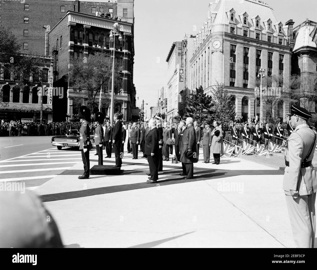 Ausflug nach Ottawa, Kanada: Kranzniederlegung am National war Memorial, Ottawa, Kanada, 9:30am Uhr. Kranzniederlegung im National war Memorial am Confederation Square, Ottawa, Ontario, Kanada. Präsident John F. Kennedy steht auf der Plattform links von zwei Mitgliedern der kanadischen Ehrengarde. Air Force Aide to the President, General Godfrey T. McHugh, und Chief of Protocol, Angier Biddle Duke, stehen auf der rechten Seite. [Foto von Harold Sellers] Stockfoto