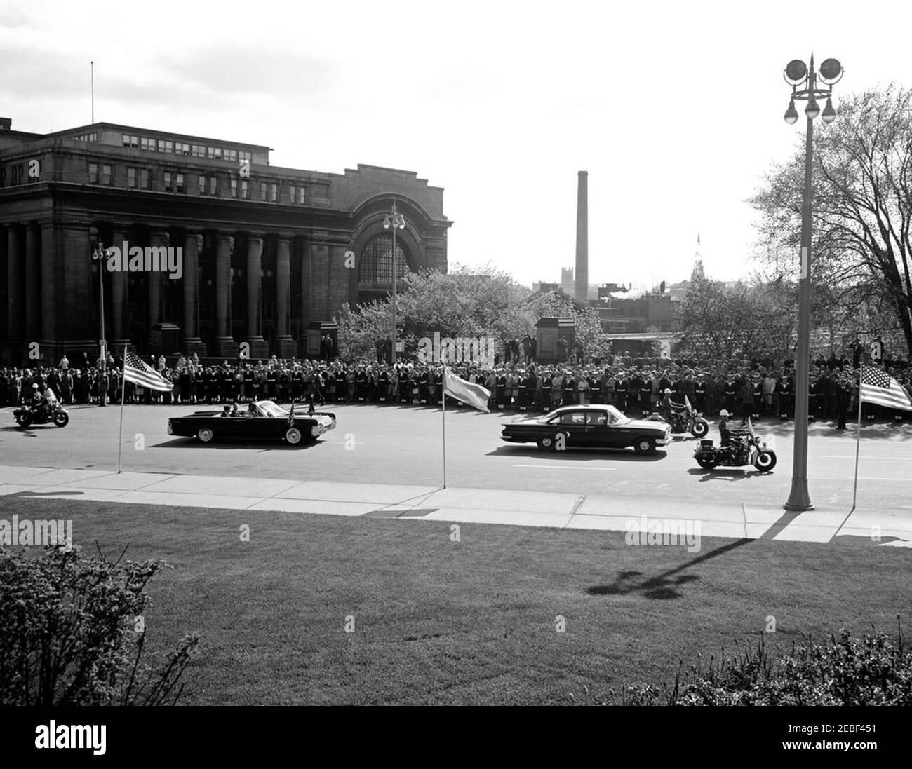 Ausflug nach Ottawa, Kanada: Kranzniederlegung am National war Memorial, Ottawa, Kanada, 9:30am Uhr. Autokolonne entlang der Rideau Street, auf dem Weg zur Kranzniederlegung am National war Memorial am Confederation Square, Ottawa, Ontario, Kanada. Präsident John F. Kennedy fährt auf dem Rücksitz des Autos auf der linken Seite; White House Secret Service Agent, Gerald u201cJerryu201d Behn, sitzt vorne. Die Ottawa Union Station liegt hinter der Menschenmenge auf der linken Seite. [Foto von Harold Sellers] Stockfoto