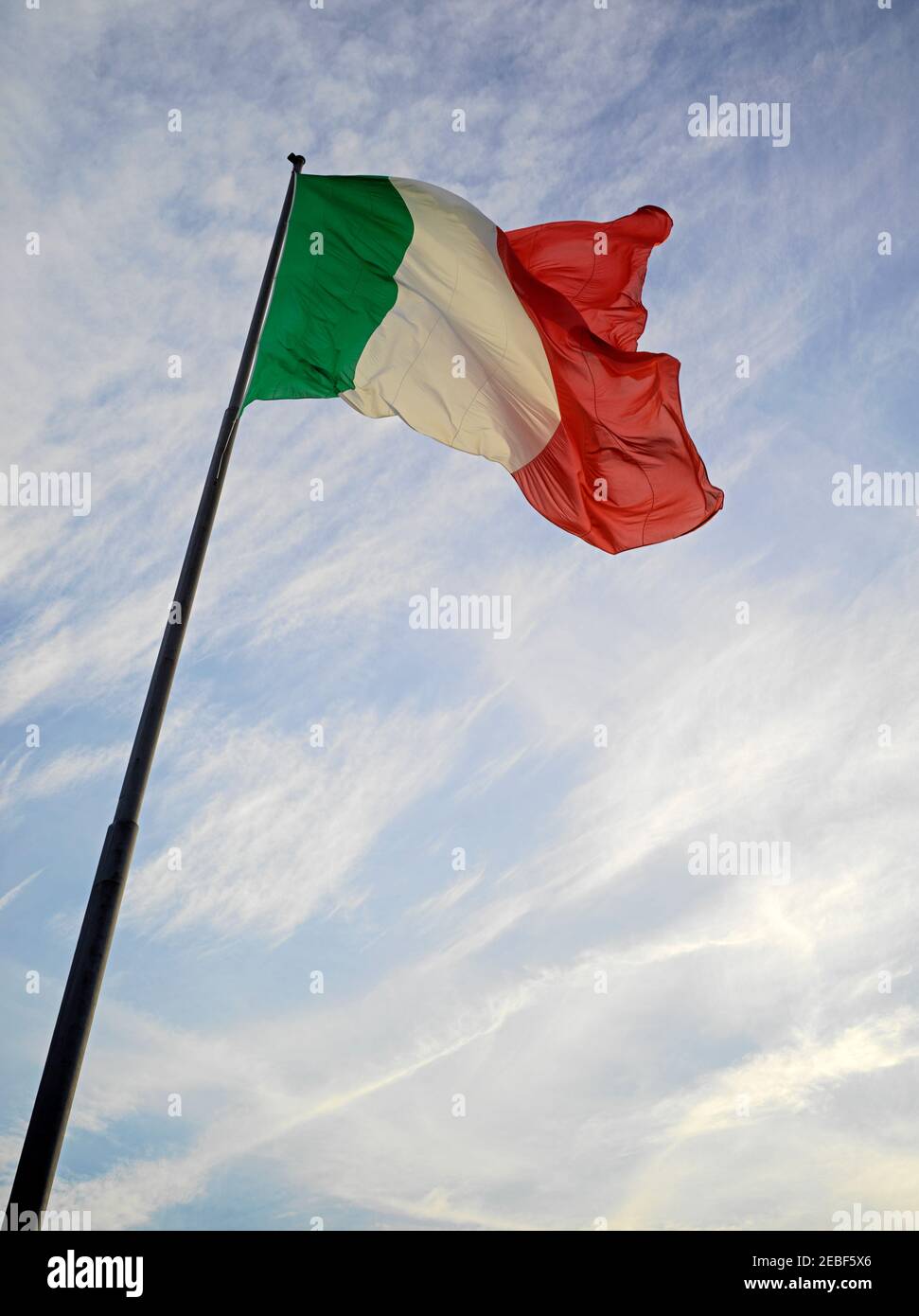 Flagge Italiens auf Mast mit Sonnenuntergang Himmel hinter Stockfoto