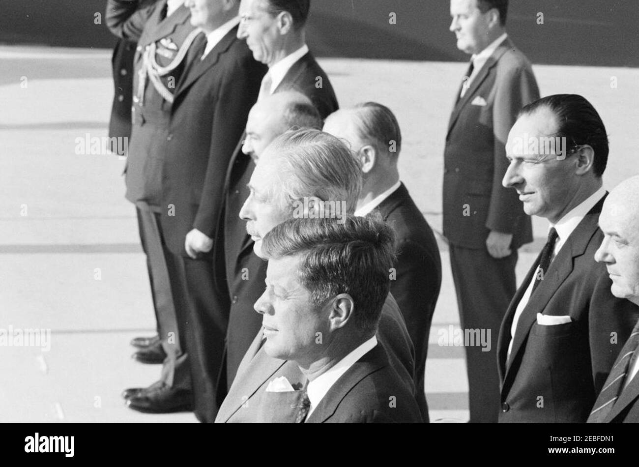 Ankunftszeremonie für Harold Macmillan, Premierminister von Großbritannien, 4:50pm Uhr. Ankunftszeremonien zu Ehren des britischen Premierministers Harold Macmillan. Auf der Überprüfungsplattform (im Vordergrund): Präsident John F. Kennedy; Premierminister Macmillan; Staatssekretär Dean Rusk (teilweise versteckt am rechten Rand des Rahmens); Botschafter Großbritanniens, Sir David Ormsby-Gore. Ebenfalls im Bild: Sekretär des Kabinetts von PMu2019s, Sir Norman Brook; stellvertretender Staatssekretär für europäische Angelegenheiten, William R. Tyler; Minister in der britischen Botschaft, Lord Hood (Viscount Samuel H. Stockfoto
