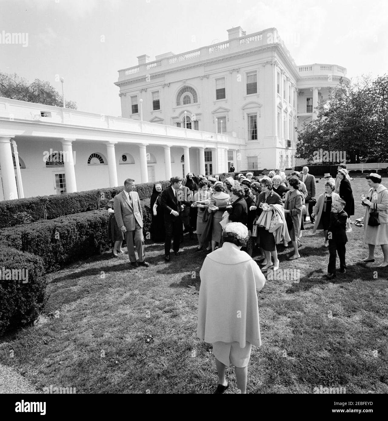 Besuch einer Newton, Massachusetts Schulgruppe. Präsident John F. Kennedy begrüßt die Schulgruppe aus Newton, Massachusetts, im Rosengarten während des Besuchs im Weißen Haus, Washington, D.C., groupu2019s. Auch im Bild: White House Secret Service Agent, Arthur L. u0022Artu0022 Godfrey. Stockfoto