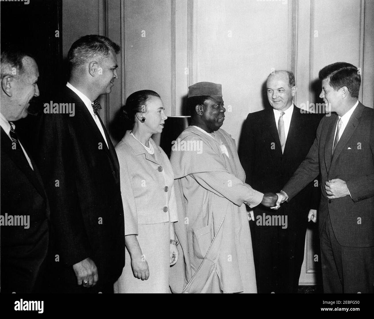 Ansprache im Außenministerium anlässlich des u0022African Freedom Day,u0022 11:30am Uhr. Präsident John F. Kennedy schüttelt die Hände mit dem Botschafter Nigerias, Julius Momo Udochi, bei einem Empfang zum Afrikanischen Tag der Freiheit im Drawing Room des State Department Auditorium, Washington, D.C., L-R: Chester B. Bowles, Präsident Kennedyu0027s Sonderbeauftragter und Berater für afrikanische, asiatische und lateinamerikanische Angelegenheiten; Stellvertretender Staatssekretär für afrikanische Angelegenheiten, G. Mennen u201cSoapyu201d Williams; Virginia Rusk; Botschafter Udochi; Staatssekretär, Dean Rusk; Präsident Kennedy. Stockfoto