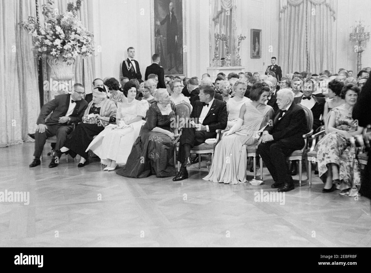Abendessen zu Ehren der Nobelpreisträger, 8:00pm Uhr. Präsident John F. Kennedy und andere treffen sich im East Room, um bei einer Lesung des Schauspielers Frederic March von Auszügen aus den Werken der späten amerikanischen Nobelpreisträger während eines Abendessens zu Ehren der Nobelpreisträger aus der westlichen Hemisphäre teilzunehmen. Platz in der ersten Reihe (L-R): Vizepräsident Lyndon B. Johnson; Katherine Tupper Marshall (Witwe des Nobelpreisträgers und ehemaligen Staatssekretärs, General George C. Marshall); Lady Bird Johnson; Nobelpreisträgerin, Pearl S. Buck; Präsident Kennedy; First Lady Jacqueline Kennedy; Lyrikerin und Nobelpreis Stockfoto