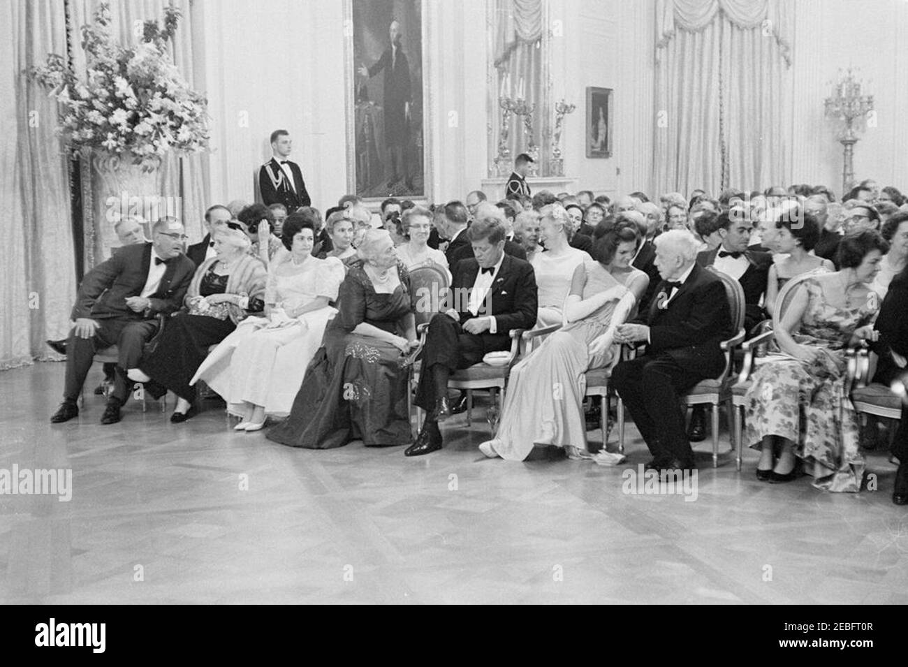 Abendessen zu Ehren der Nobelpreisträger, 8:00pm Uhr. Präsident John F. Kennedy und andere treffen sich im East Room, um bei einer Lesung des Schauspielers Frederic March von Auszügen aus den Werken der späten amerikanischen Nobelpreisträger während eines Abendessens zu Ehren der Nobelpreisträger aus der westlichen Hemisphäre teilzunehmen. Platz in der ersten Reihe (L-R): Vizepräsident Lyndon B. Johnson; Katherine Tupper Marshall (Witwe des Nobelpreisträgers und ehemaligen Staatssekretärs, General George C. Marshall); Lady Bird Johnson; Nobelpreisträgerin, Pearl S. Buck; Präsident Kennedy; First Lady Jacqueline Kennedy; Lyrikerin und Nobelpreis Stockfoto