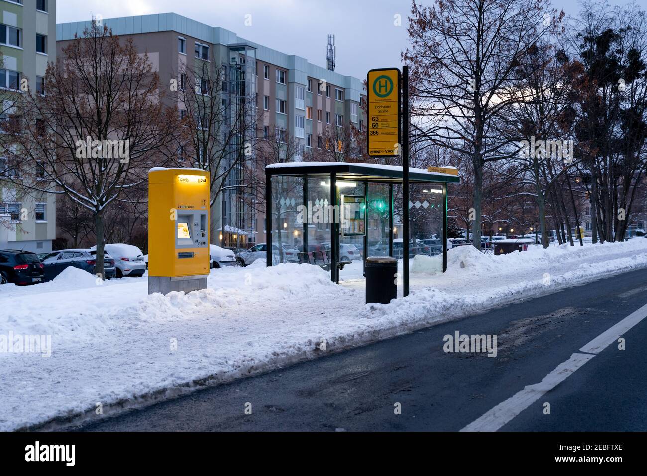 DVB-Bushaltestelle Dorfhainer Straße am Abend während der Wintersaison. Auf dem Bürgersteig liegt viel Schnee. Dresdner Verkehrsbetriebe Stockfoto