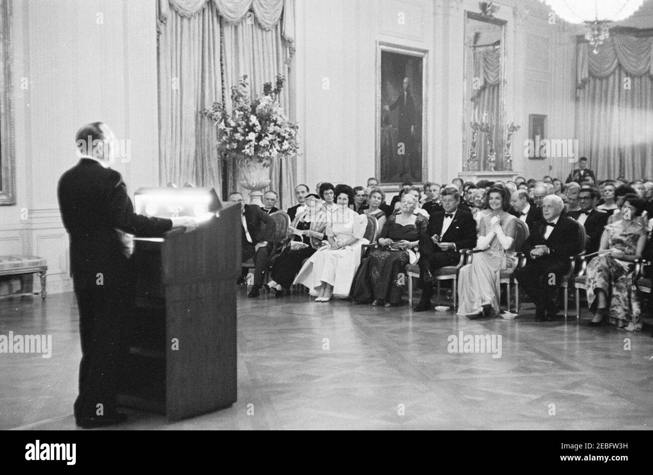 Abendessen zu Ehren der Nobelpreisträger, 8:00pm Uhr. Der Schauspieler Frederic March (links) führt während eines Abendessens zu Ehren der Nobelpreisträger der westlichen Hemisphäre Auszüge aus den Werken des verstorbenen Nobelpreisträgers, des ehemaligen Staatssekretärs, General George C. Marshall, und der Autoren Sinclair Lewis und Ernest Hemingway vor. Platz in der ersten Reihe (L-R): Vizepräsident Lyndon B. Johnson (teilweise versteckt); Katherine Tupper Marshall (Witwe von General Marshall); Lady Bird Johnson; Nobelpreisträger, Pearl S. Buck; Präsident John F. Kennedy; First Lady Jacqueline Kennedy; Dichter und N Stockfoto