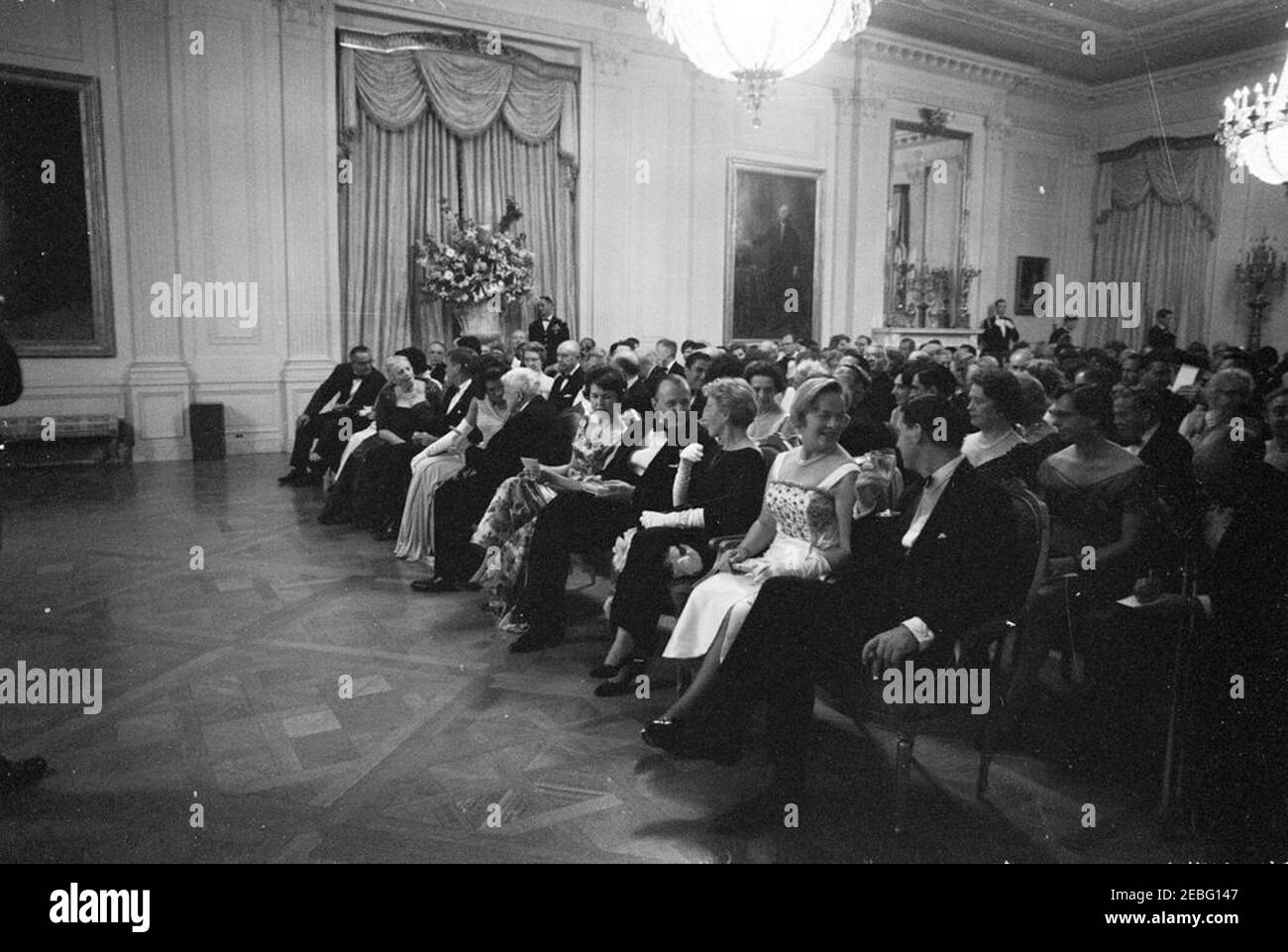Abendessen zu Ehren der Nobelpreisträger, 8:00pm Uhr. Präsident John F. Kennedy und andere treffen sich im East Room, um bei einer Lesung des Schauspielers Frederic March von Auszügen aus den Werken der späten amerikanischen Nobelpreisträger während eines Abendessens zu Ehren der Nobelpreisträger aus der westlichen Hemisphäre teilzunehmen. Platz in der ersten Reihe (L-R): Vizepräsident Lyndon B. Johnson; Katherine Tupper Marshall (Witwe des Nobelpreisträgers und ehemaligen Staatssekretärs, General George C. Marshall), meist versteckt; Lady Bird Johnson (meist versteckt); Nobelpreisträgerin, Pearl S. Buck; Präsident Kennedy; First Lady Jacquelin Stockfoto