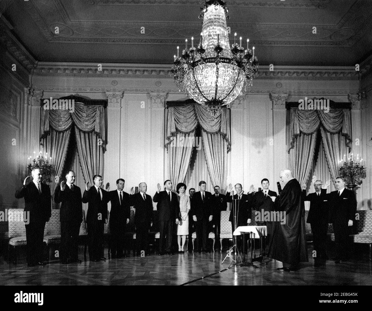 Vereidigung und Empfang der Kabinettsminister, 4:00pm Uhr. Vereidigung in Zeremonie für Kabinettsmitglieder, East Room, White House, Washington, D.C. Chief Justice Earl Warren schwört-in Präsident John F. Kennedyu0027s Kabinettsmitglieder. (L-R) vordere Reihe: Staatssekretär Dean Rusk; Finanzminister C. Douglas Dillon; Verteidigungsminister Robert S. McNamara; Generalstaatsanwalt Robert F. Kennedy; Generalpostmeister J. Edward Day; Innenminister Stewart Udall; First Lady Jacqueline Kennedy; Präsident Kennedy; Botschafter der Vereinigten Staaten bei den Vereinten Nationen Adlai E. Stevenson; SE Stockfoto