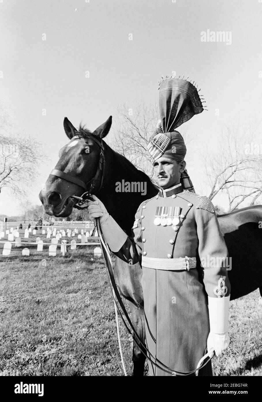 First Lady Jacqueline Kennedy (JBK) und Caroline Kennedy (CBK) erhalten u0022Sardar,u201d ein Pferd, das vom pakistanischen Präsidenten Ayub Khan in Fort Myer Stables, Arlington, Virginia, geschenkt wurde. Ein nicht identifizierter pakistanischer Militäroffizier steht mit u0022Sardar,u0022 dem Pferd, das First Lady Jacqueline Kennedy als Geschenk des pakistanischen Präsidenten Mohammad Ayub Khan während ihrer Reise nach Pakistan gegeben wurde. Fort Myer Stables, Arlington, Virginia. Stockfoto