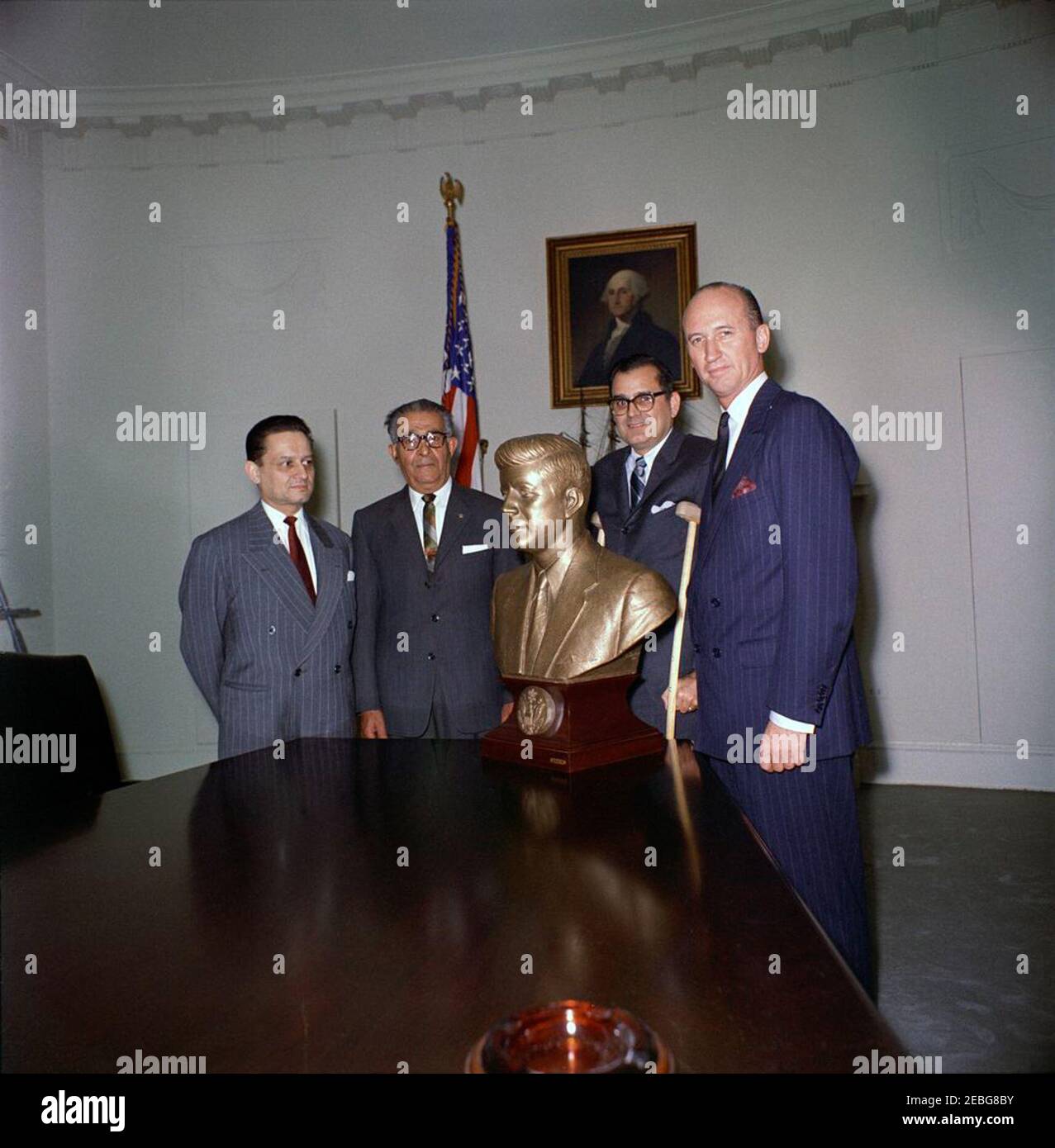 Büste von Präsident Kennedy dem Weißen Haus vorgestellt. Chef des Protokolls, Angier Biddle Duke (ganz rechts), nimmt eine Büste von Präsident John F. Kennedy (gemeißelt von Carlos Pazos von Lima, Peru) als Geschenk für das Weiße Haus; drei andere Männer sind nicht identifiziert. Kabinettsaal, Weißes Haus, Washington, D.C. [siehe auch MO 63,653, u201cBust von John F. Kennedyu201d] Stockfoto