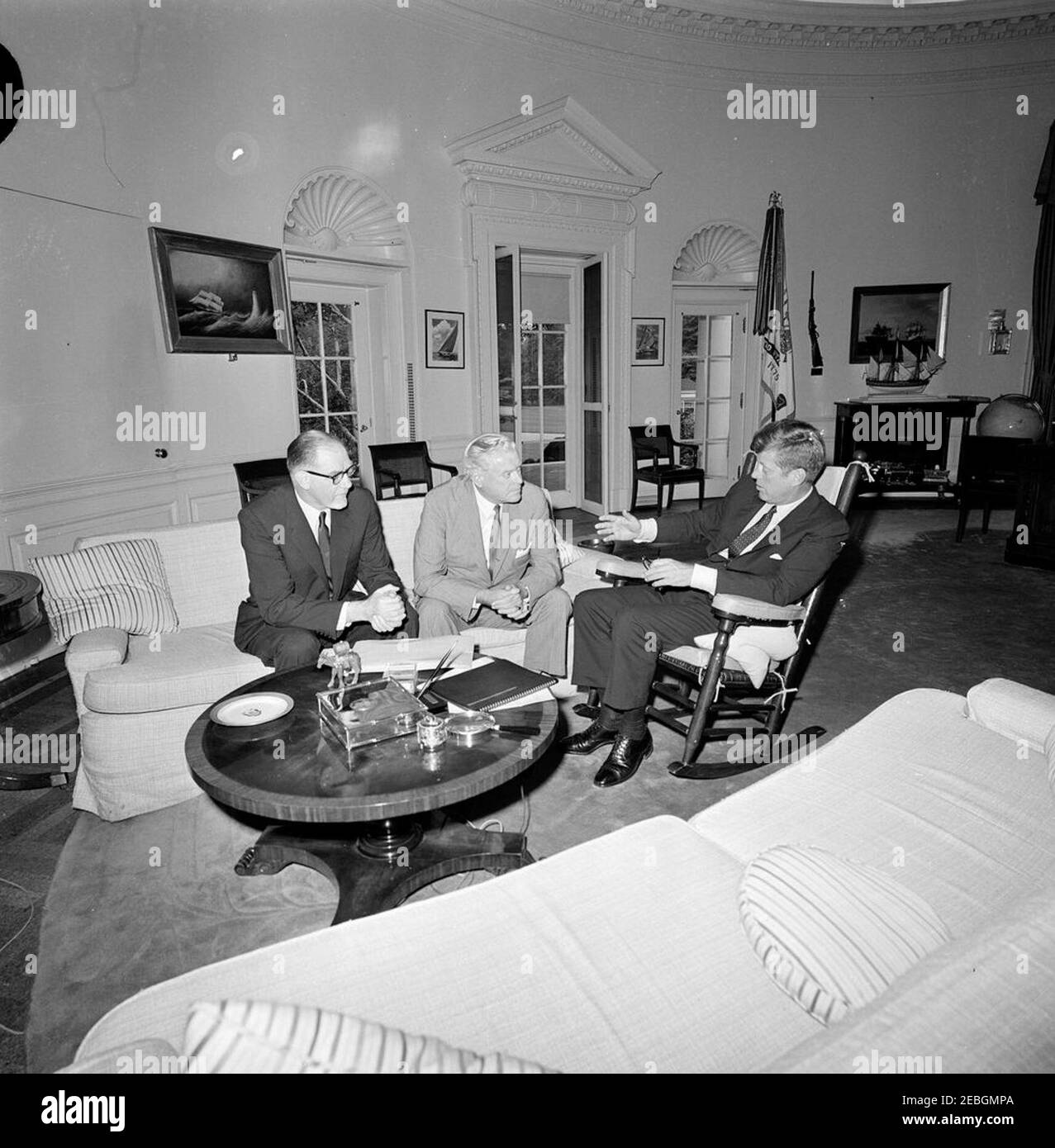 Treffen mit Roger Blough, U. S. Steel Corporation, u0026 David J. McDonald, United Steel Workers of America. Präsident John F. Kennedy (rechts, im Schaukelstuhl) trifft sich mit dem Vorstandsvorsitzenden der U.S. Steel Corporation, Roger M. Blough (links), und dem Präsidenten der United Steelworkers of America, David J. McDonald (Mitte). Oval Office, White House, Washington, D.C. [Anmerkungen: Flecken auf dem Bild sind original zum Negativen.] Stockfoto