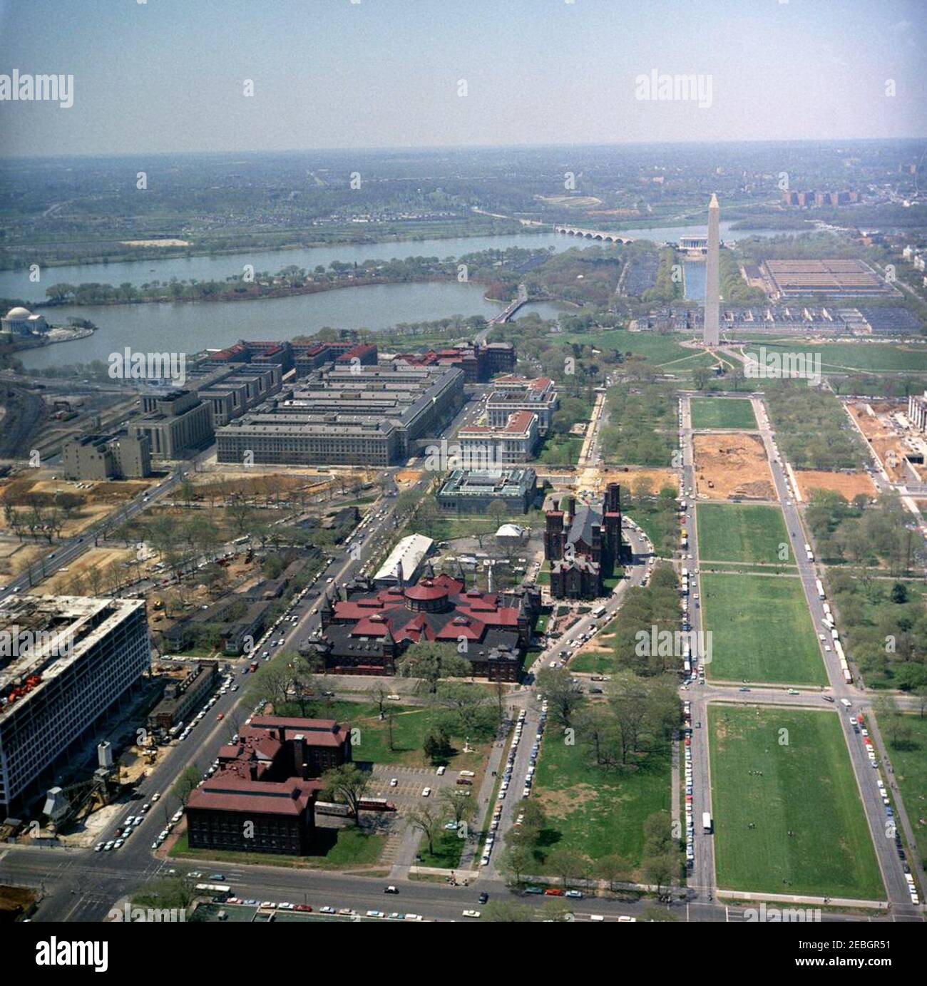 Luftaufnahmen von Washington, D.C., u0026 Umgebung. Luftaufnahme der National Mall in Washington, D.C., mit den Smithsonian Institutionu2019s Arts and Industries and Castle Gebäuden im Zentrum und dem Museum of History and Technology (im Bau, am Rand des Rahmens) ganz rechts. Im Hintergrund rechts sind das Washington Monument, der reflektierende Pool und das Lincoln Memorial; das Thomas Jefferson Memorial ist am Ufer des Potomac River oben links zu sehen. Stockfoto