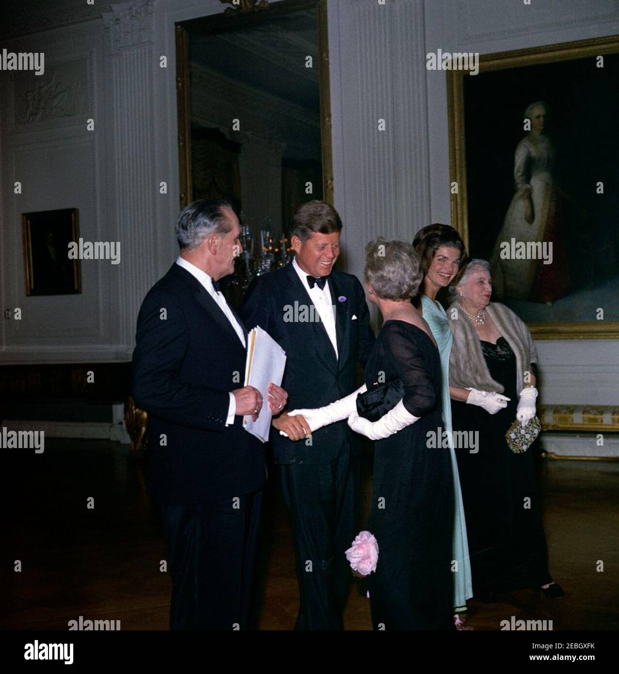 Abendessen zu Ehren der Nobelpreisträger, 8:00pm Uhr. Präsident John F. Kennedy besucht mit Gästen den East Room während eines Abendessens zu Ehren der Nobelpreisträger aus der westlichen Hemisphäre. Von links nach rechts: Schauspieler, Frederic March; Präsident Kennedy; Schriftstellerin Mary Welsh Hemingway (Witwe des Nobelpreisträgers Ernest Hemingway), dem Präsidenten die Hände schüttelnd; First Lady Jacqueline Kennedy und Katherine Tupper Marshall (Witwe des Nobelpreisträgers und ehemaligen Staatssekretärs, General George C. Marshall). White House, Washington, D.C. Stockfoto