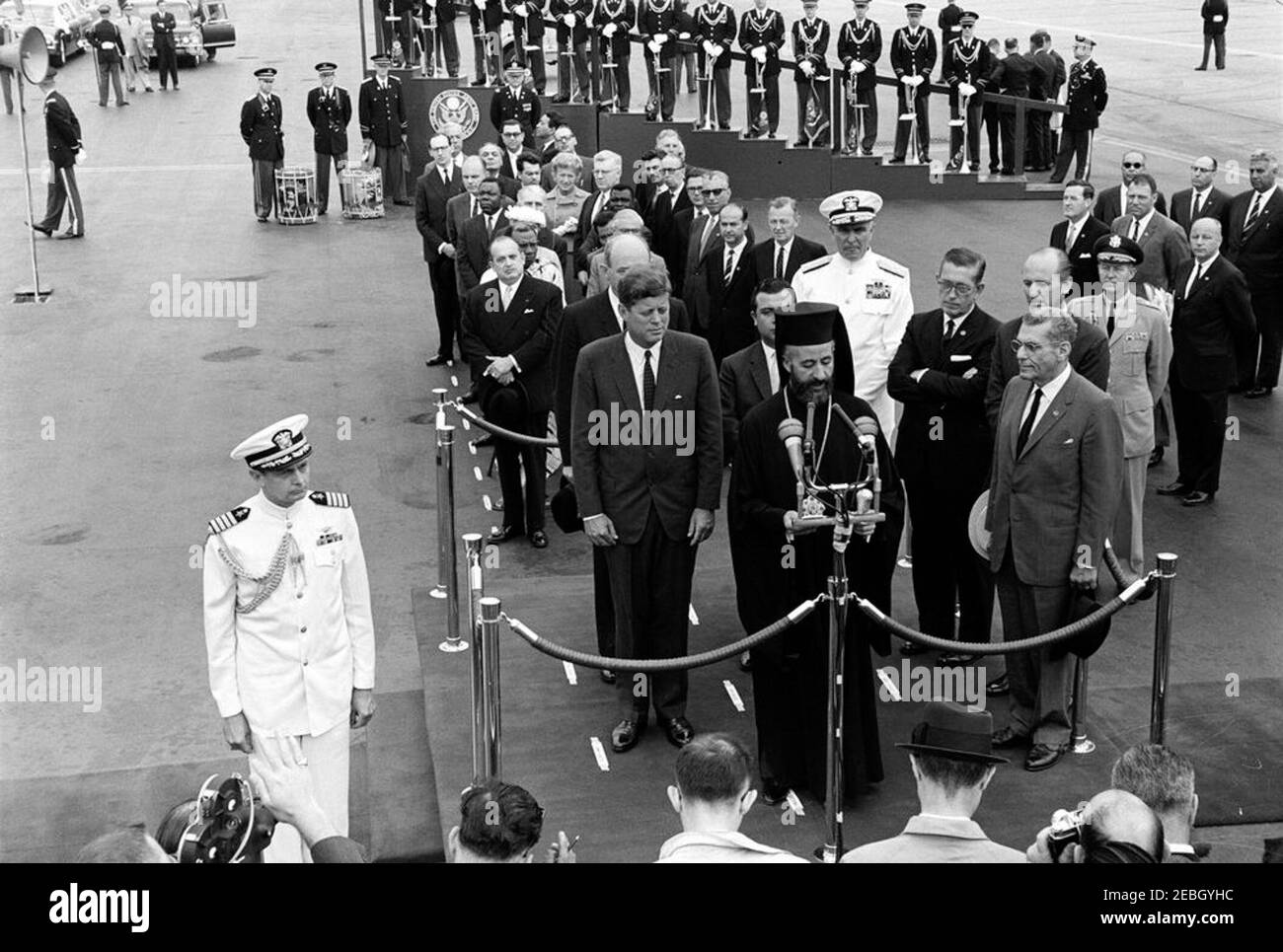 Zeremonie zur Ankunft von Erzbischof Makarios III., Präsident von Zypern, 11:00am Uhr. Der Präsident der Republik Zypern, Erzbischof Makarios III., hält zu seinen Ehren bei den Ankunftszeremonien eine Rede. Auf der Überprüfungsplattform (L-R): US-Außenminister Dean Rusk (hinten, teilweise versteckt); Präsident John F. Kennedy; Außenminister der Republik Zypern, Spyros Kyprianou (teilweise versteckt); Erzbischof Makarios III (an Mikrofonen); Leiter der Marineoperationen, Admiral George W. Anderson, Jr. (U.N.); US-Botschafter in Zypern, Fraser Wilkins; US-Chef des Protokolls, Angier Stockfoto