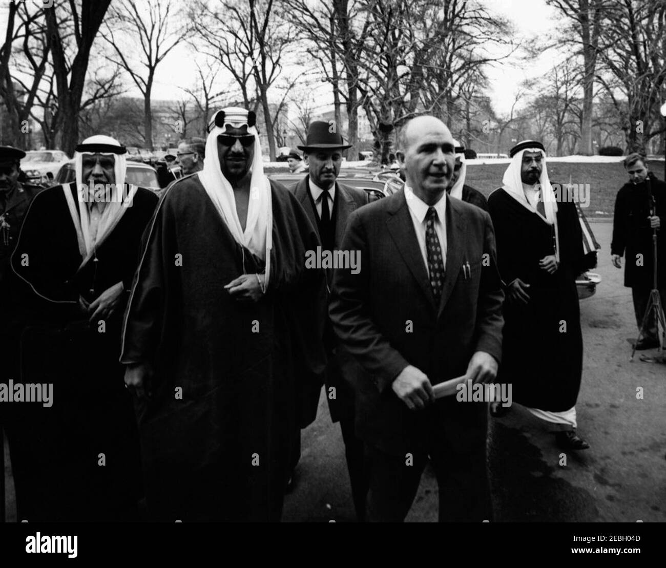 Ankunftzeremonien für Saud bin Abdul Aziz, König von Saudi-Arabien, 3:00pm Uhr. Sonderassistent des Präsidenten Dave Powers eskortiert König von Saudi-Arabien Saud bin Abdul-Aziz Al Saud (mit Sonnenbrille) und seine Partei am südlichen Eingang des Weißen Hauses. Chef des Protokolls Angier Biddle Duke (trägt Hut) geht hinter Kräfte. South Lawn, White House, Washington, D.C. Stockfoto