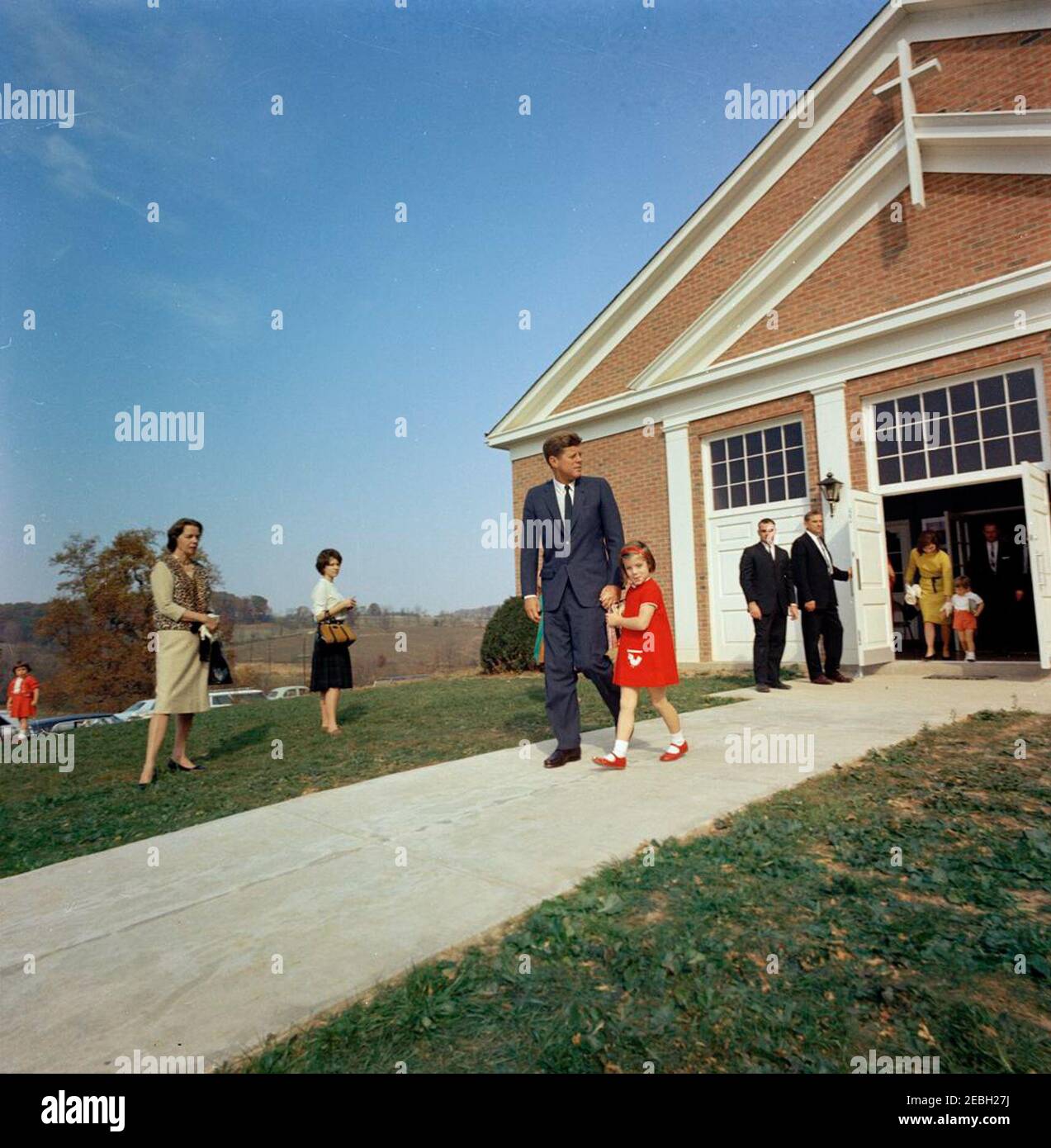 Wochenende in Atoka: Präsident und Frau Kennedy mit Kindern verlassen St. Stephen der Märtyrer Kirche, 10:40 UHR. Präsident John F. Kennedy verlässt St. Stephen the Martyr Church mit seiner Tochter, Caroline Kennedy, nach der Teilnahme an der Messe; First Lady Jacqueline Kennedy verlässt mit John F. Kennedy, Jr., auf der rechten Seite. Auch abgebildet: White House Secret Service Agent, Walt Coughlin. Middleburg, Virginia. Stockfoto