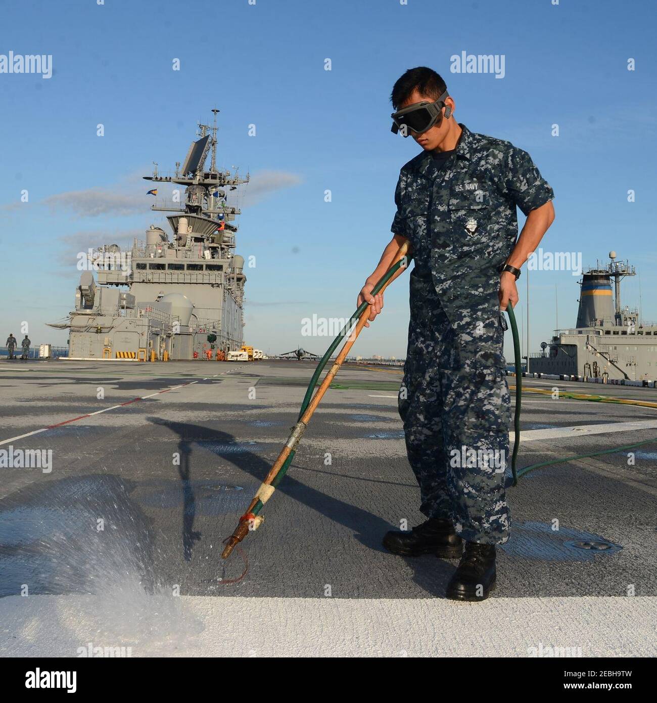 NORFOLK, VA. (AUG. 22, 2016) -- der chinesische Immigrant, der Flugflieger Bo Lu, nutzt Druckluft, um Wasser aus den Augen des Flugdecks des amphibischen Sturmschiffes USS Bataan (LHD 5) zu entfernen. 160822 Stockfoto