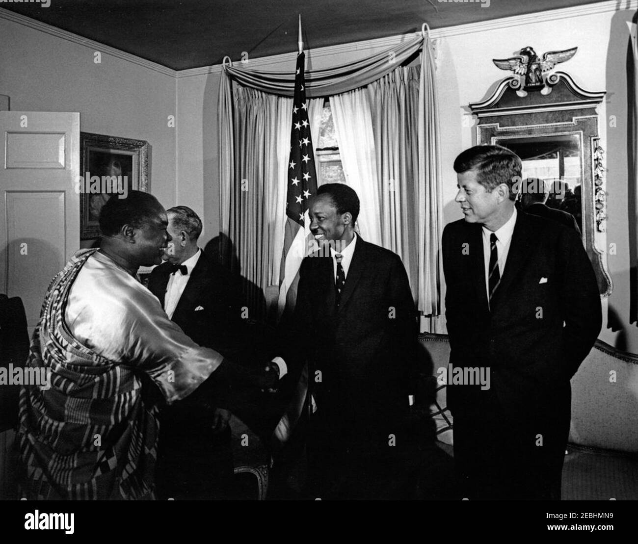 Empfang zu Ehren von Präsident Kennedy, gegeben von Julius Nyerere, Präsident von Tanganyika, 6:20pm Uhr. Präsident John F. Kennedy (rechts) nimmt an einem Empfang Teil, den der Präsident von Tanganyika, Julius Nyerere (Mitte), zu seinen Ehren in der Residenz des US-Protokollchef Angier Biddle Duke hielt. Andere sind nicht identifiziert. Washington, D.C. Stockfoto