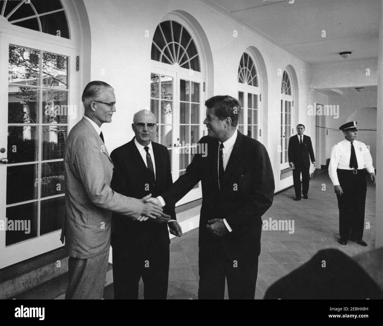 Treffen mit Mitgliedern des Senior Seminar in Foreign Policy des Foreign Service Institute, 3:30pm Uhr. Präsident John F. Kennedy schüttelt sich bei einem Treffen mit Mitgliedern des Senior Seminar in Foreign Policy des Foreign Service Institute (FSI) die Hände mit einem unbekannten Mann; Direktor des FSI, Carl W. Strom, steht im Zentrum. Im Hintergrund stehen der Sonderassistent des Präsidenten, Kenneth P. Ou2019Donnell, und ein nicht identifizierter Polizist des Weißen Hauses. West Wing Colonnade, White House, Washington, D.C. Stockfoto