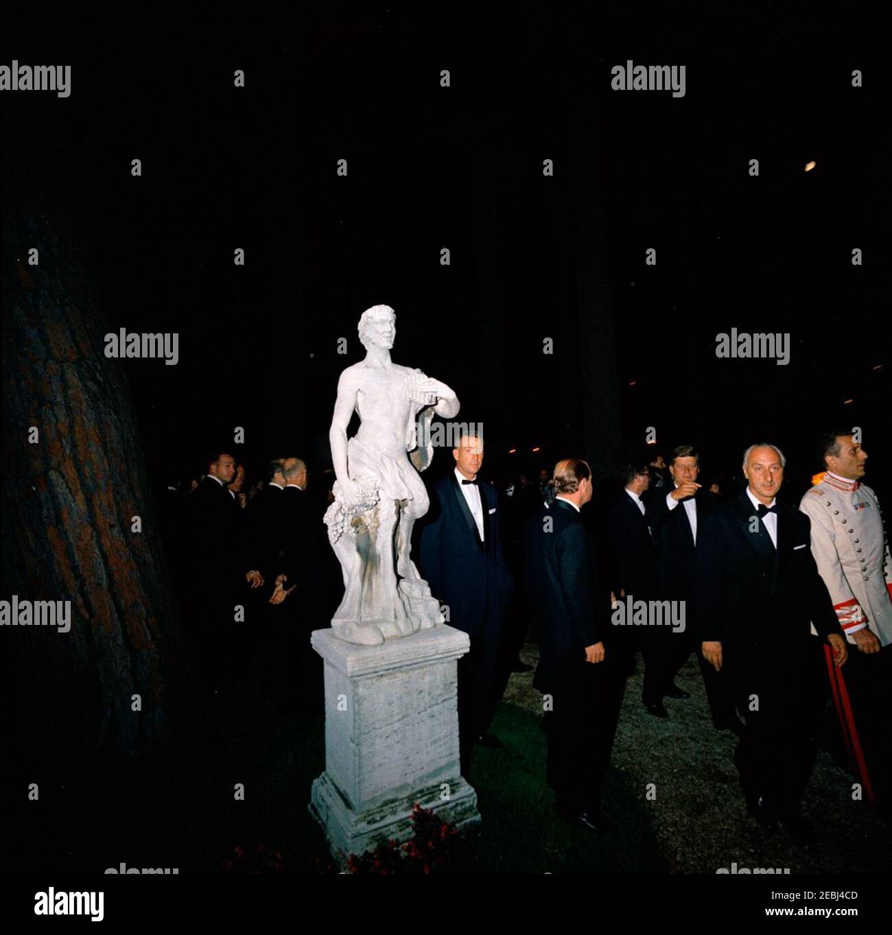 Europareise: Italien, Rom: Präsident Kennedy beim Abendessen im Quirinale Palace. Präsident Antonio Segni von Italien auch abgebildet. Präsident John F. Kennedy (Dritter von rechts) geht auf dem Gelände des Quirinale-Palastes in Rom, Italien, wo ein Abendessen zu seinen Ehren vom italienischen Präsidenten Antonio Segni gegeben wurde. White House Secret Service Agent, Art Godfrey, steht rechts von der Statue. Stockfoto