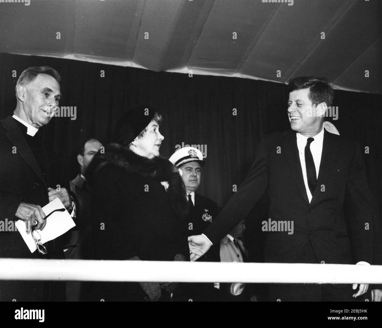 Dedication Ceremonies, Dulles International Airport, 11:12am Uhr. Präsident John F. Kennedy nimmt an der Einweihungszeremonie für den internationalen Flughafen Dulles Teil, benannt nach dem verstorbenen Außenminister John Foster Dulles. Von links nach rechts: Kaplan des Senats der Vereinigten Staaten, Reverend Frederick Brown Harris; nicht identifiziert (hinten); Janet Avery Dulles (Witwe des ehemaligen Sekretärs Dulles); Chef der Naval Operations, Admiral George W. Anderson, Jr.; Präsident Kennedy. Chantilly, Virginia. Stockfoto