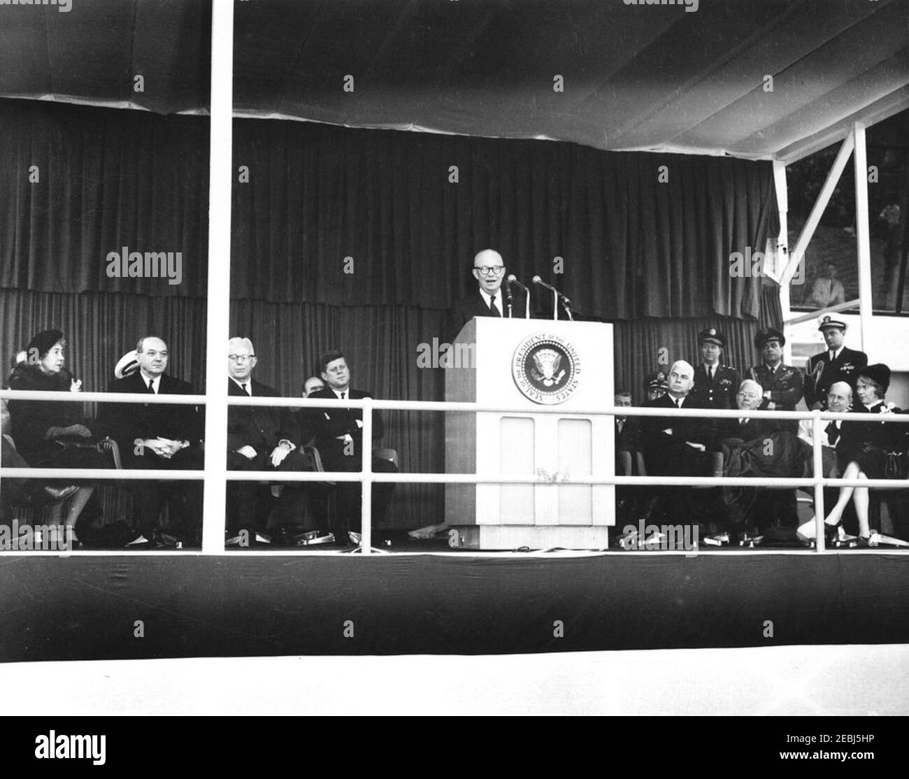 Dedication Ceremonies, Dulles International Airport, 11:12am Uhr. Der ehemalige Präsident, General Dwight D. Eisenhower (am Rednerpult), hält bei der Einweihungszeremonie für den internationalen Flughafen Dulles, benannt nach dem verstorbenen Außenminister John Foster Dulles, Bemerkungen; Präsident John F. Kennedy sitzt links vom Rednerpult. Auf speakersu0027 Plattform, links von Rednerpult: Janet Avery Dulles (Witwe des ehemaligen Sekretärs Dulles); Staatssekretär, Dekan Rusk; Oberrichter des Obersten Gerichtshofs, Earl Warren; stellvertretender Administrator der Federal Aviation Agency (FAA), Generalleutnant Harold W. Grant; Präsident Kenne Stockfoto