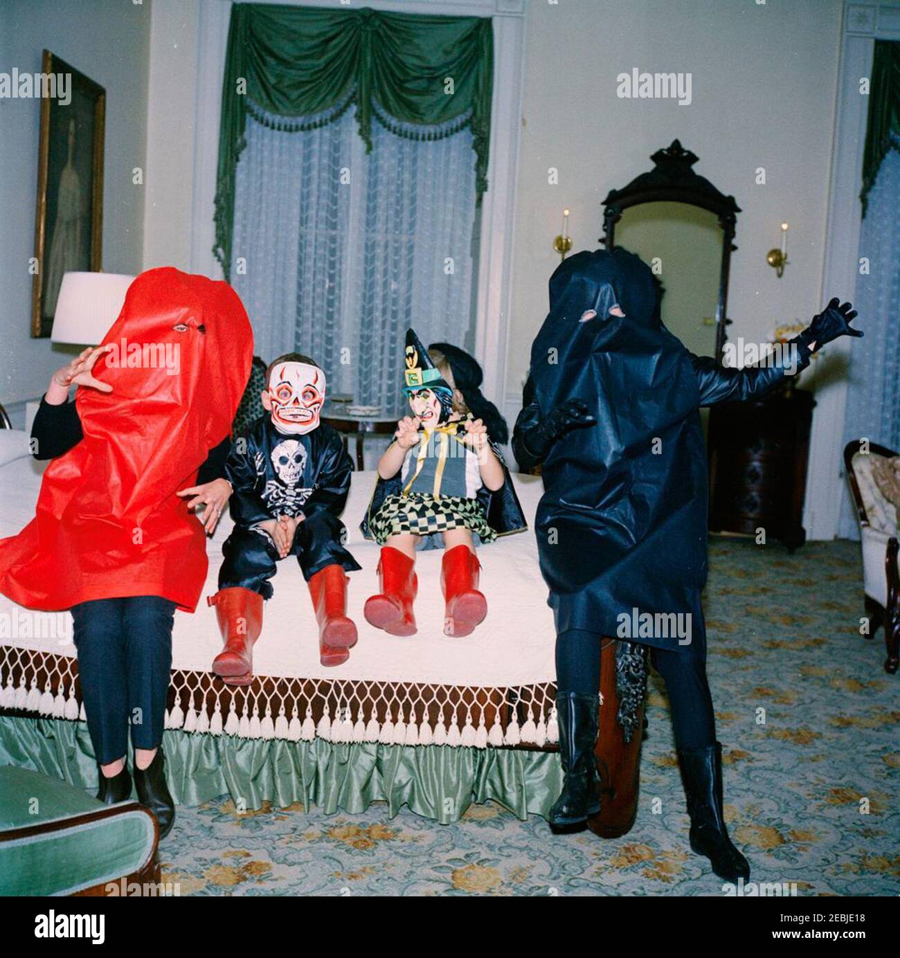 Kinder in Halloween Kostümen. Jean Kennedy Smith, Steve Smith, Jr., Caroline Kennedy und First Lady Jacqueline Kennedy (ganz rechts) posieren in ihren Halloween Kostümen. Lincoln Schlafzimmer, White House, Washington, D.C. Stockfoto