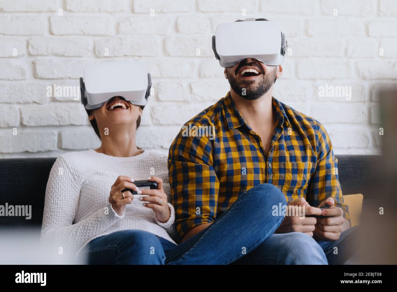 Junges Paar Spielt Virtual Reality Mit Headset Auf Sofa Stockfoto