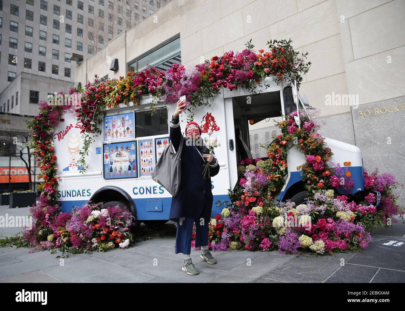 Eine Frau macht ein Selfie in der Nähe eines Mister Softee Eisdielwagens, der mit Blumen bedeckt ist, zur Feier des bevorstehenden Valentinstags-Feiertags im Rockefeller Center in New York City am Freitag, dem 12. Februar 2021. Zur Feier des Valentinstags und als Teil des Rockefeller Center-Monats "Liebe im Zentrum" stellte der renommierte Blumendesigner Lewis Miller Design zwei maßgeschneiderte Mister Softee Trucks aus, die mit Tausenden von bunten Rosen, Hortensien, Narzissen, Chrysanthemen, Mimosen und mehr kaskadierten. Foto von John Angelillo/UPI Stockfoto