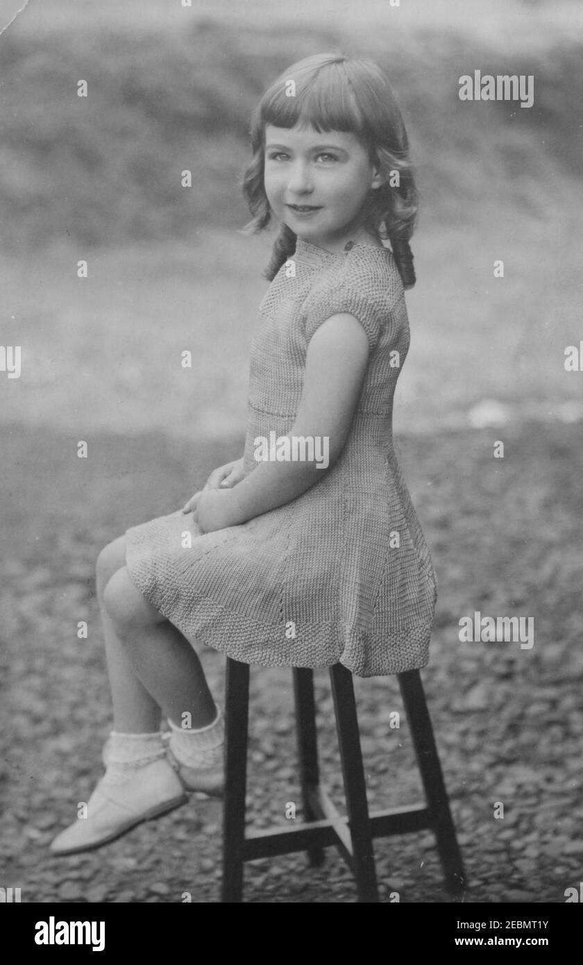 Vintage monochrome Fotografie eines hübschen jungen kaukasischen Mädchen mit Ringel, aus der Edwardianischen Ära 1920s. Stockfoto
