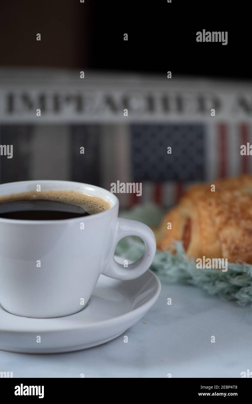 Guten Morgen Amerika, Donald Trump wurde wieder angeklagt, Stilleben mit Zeitung, Kaffee und Croissant Stockfoto